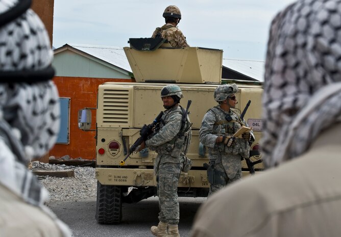 NEVADA TEST AND TRAINING RANGE -- 1st Lt. Ralph Johnson, Staff Sgt. Pablo Cancel, 820th Base Defense Group, patrol a mock Iraqi village and talk with Airman posing as Iraqi Villagers in a field exercise at exercise Desert Eagle March 15. Desert Eagle is integrated training between No.1 Squadron, RAF Regiment and the 820th Base Defense Group Moody Air Force Base Ga., to improve both nations ability to work together during present and future contingencies. (U.S. Air Force photo by Airman 1st Class Daniel Hughes)