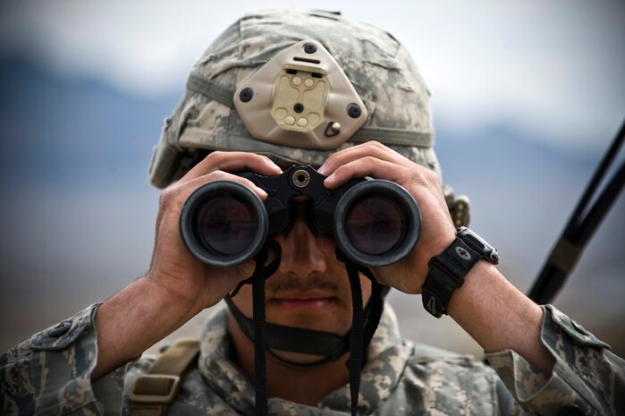 NEVADA TEST AND TRAINING RANGE -- Senior Airman Brent Glover, 822nd Base Defense Squadron, Moody Air Force Base Ga., looks through binoculars during a field training exercise on the NTTR as part of exercise Desert Eagle March 16. Desert Eagle is an integrated training between No. 1 Squadron, Royal Air Force Regiment and the 820th Base Defense Group from Moody Air Force Base, Ga., to improve both nations ability work together during present and future contingencies.(U.S. Air Force photo by Senior Airman Brett Clashman)
