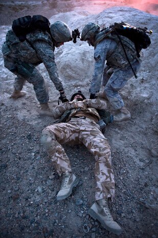 NEVADA TEST AND TRAINING RANGE -- Airman 1st Class Eddie Morgan and Airman 1st Class Kyle Selsor, 822nd Base Defense Squadron, Moody Air Force Base Ga., drag Royal Air Force Senior Aircraftsman Gareth Dight, No. 1 Squadron, Regiment 4 Force Protection Wing security forces out of imminent danger after being wounded during a field training exercise on the NTTR as part of exercise Desert Eagle March 16. Desert Eagle is an integrated training between No. 1 Squadron, Royal Air Force Regiment and the 820th Base Defense Group from Moody Air Force Base, Ga., to improve both nations ability work together during present and future contingencies.(U.S. Air Force photo by Senior Airman Brett Clashman)