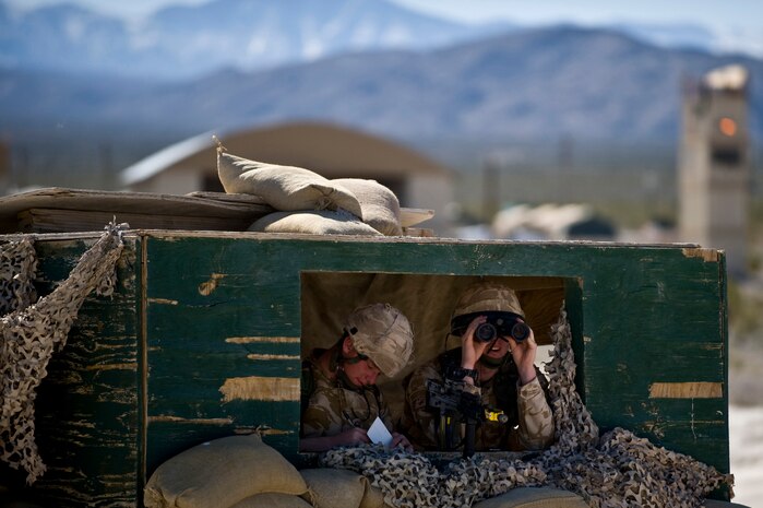 NEVADA TEST AND TRAINING RANGE -- Royal Air Force Senior Aircraftsman Michael Johnson-Rowa and Lance Cpl. Michael Walsh, No.1 Squadron, Regiment 4 Force Protection Wing security forces, scan for enemies while inside a observation tower during a field training exercise at exercise Desert Eagle on the NTTR March 15. Desert Eagle is integrated training between No.1 Squadron, RAF Regiment and the 820th Base Defense Group Moody Air Force Base Ga., to improve both nations ability to work together during present and future contingencies. (U.S. Air Force photo by Airman 1st Class George Goslin)