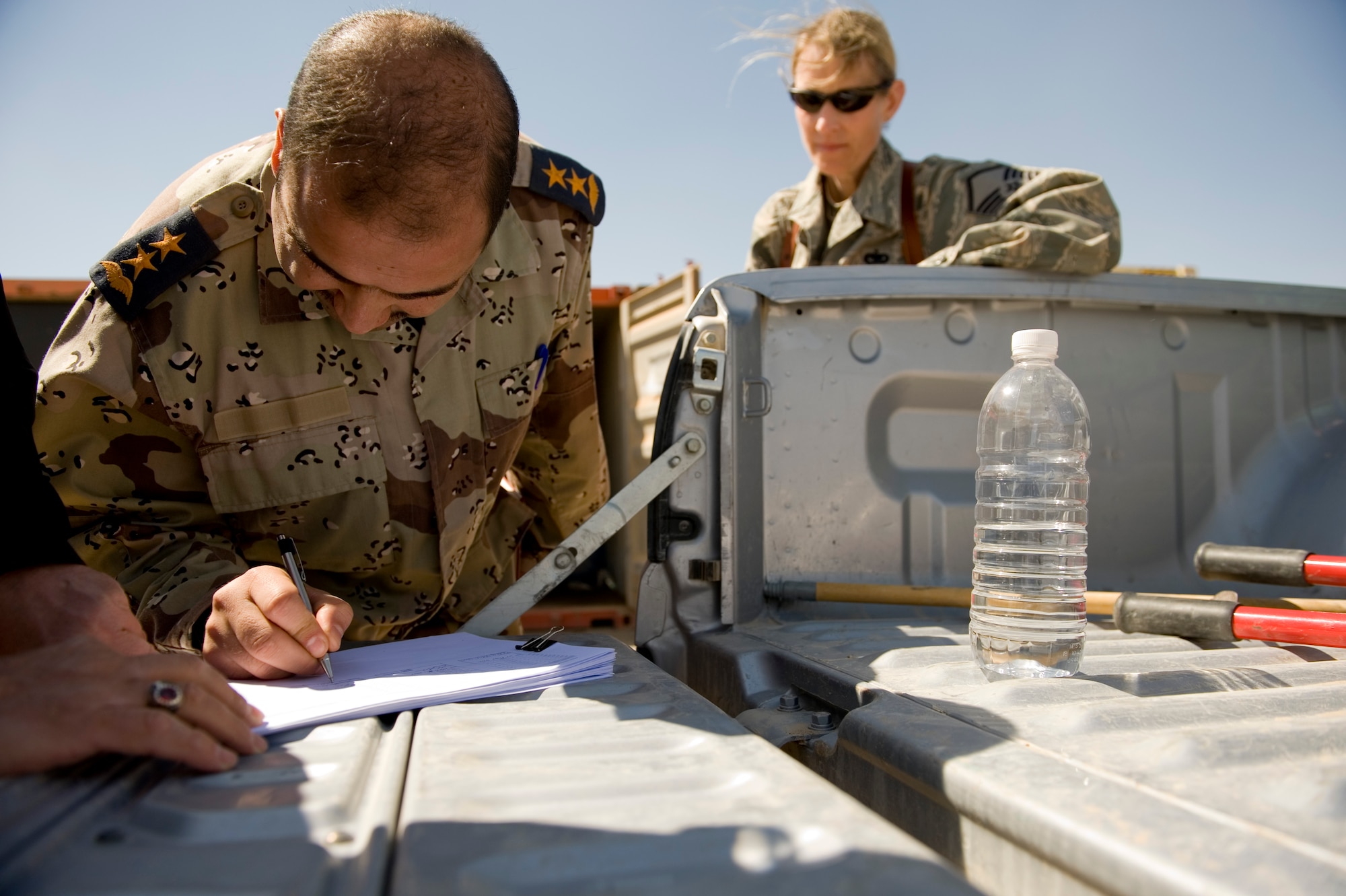 TIKRIT, Iraq -- An Iraqi logistics officer signs for equipment March 17. The transfer, involving five crates and more than $300,000 of equipment, is part of more than $7 million in assets being transferred in order to save money on shipping costs and strengthen the U.S. partnership with Iraq. (U.S. Air Force photo by Staff Sgt. Levi Riendeau)
