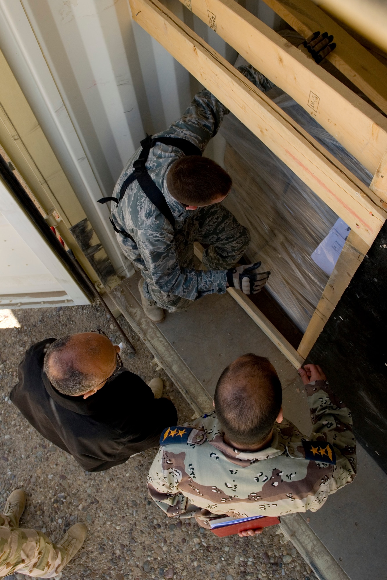 TIKRIT, Iraq -- 2nd Lt. John Ouellet III, Iraq Training and Advisory Mission-Air officer in charge of the foreign excess personal property program, inspects a container before transfer to the Iraqi military March 17. The transfer, involving five crates and more than $300,000 of equipment, is part of more than $7 million in assets being transferred in order to save money on shipping costs and strengthen the U.S. partnership with Iraq. Lieutenant Ouellet is deployed from the 60th Aerial Port Squadron, Travis Air Force Base, Calif., and is a native of Los Gatos, Calif. (U.S. Air Force photo by Staff Sgt. Levi Riendeau)