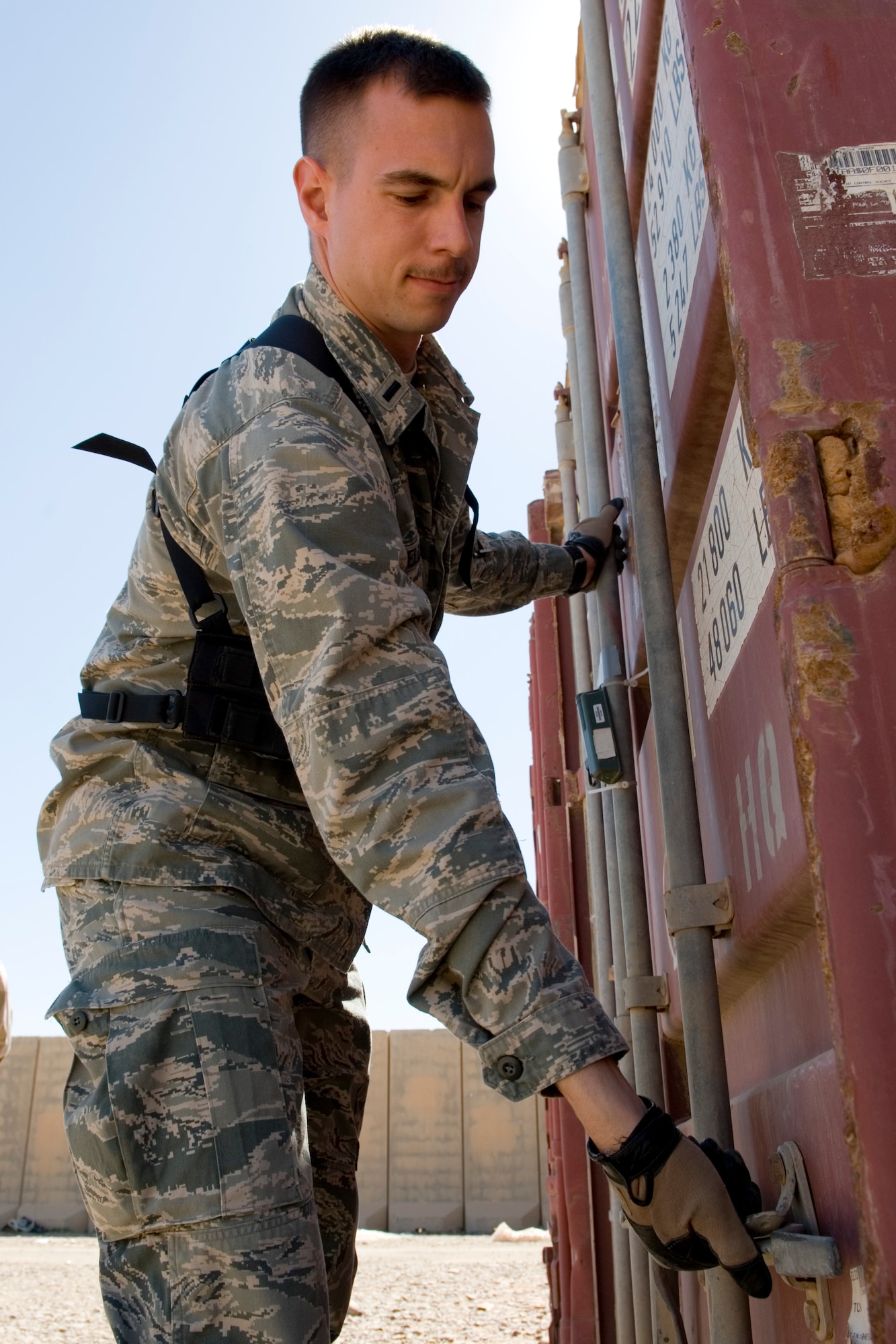 TIKRIT, Iraq -- 2nd Lt. John Ouellet III, Iraq Training and Advisory Mission-Air officer in charge of the foreign excess personal property program, opens a container to inspect its contents before transfer to the Iraqi military March 17. The transfer, involving five crates and more than $300,000 of equipment, is part of more than $7 million in assets being transferred in order to save money on shipping costs and strengthen the U.S. partnership with Iraq. Lieutenant Ouellet is deployed from the 60th Aerial Port Squadron, Travis Air Force Base, Calif., and is a native of Los Gatos, Calif. (U.S. Air Force photo by Staff Sgt. Levi Riendeau)