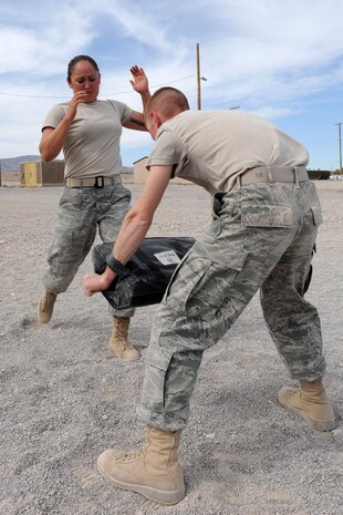 NEVADA TEST AND TRAINING RANGE -- Airman 1st Class Meghan Hilton and her partner, Airman 1st Class Kevin Brown,from the 822nd Base Defense Squadron, Moody Air Force Base, Ga., practice front kicks in Krav Maga combat self defense training during Exercise Desert Eagle March 9. Exercise Desert Eagle is integrated training between No. 1 Squadron, Royal Air Force Regiment and the 820th Base Defense Group from Moody Air Force Base, Ga., to improve both nations ability to work together during present and future contingencies. (U.S. Air Force photo by Staff Sgt. Taylor Worley)