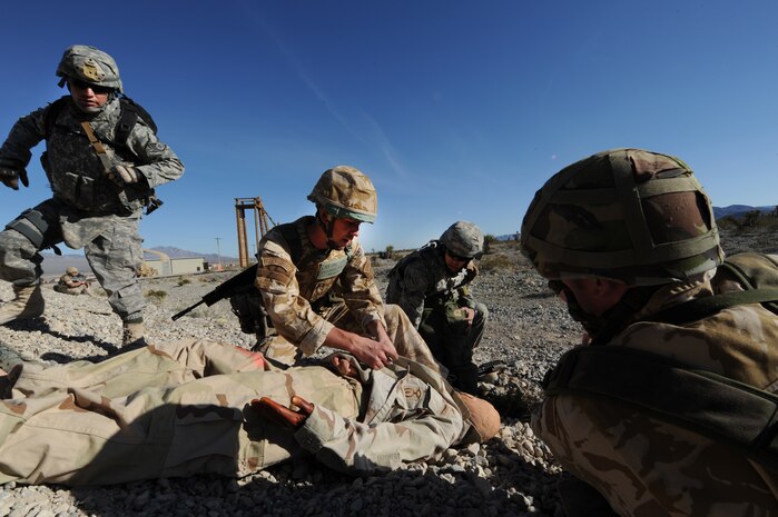 NEVADA TEST AND TRAINING RANGE -- Royal Air Force Senior Aircraftsman James McLean, No. 1 Squadron, Regiment 4 Force Protection Wing security forces, administers first aide to a civilian causality during Exercise Desert Eagle March 8.  Desert Eagle is integrated training between No. 1 Squadron, Royal Air Force Regiment and the 820th Base Defense Group from Moody Air Force Base, Ga., to improve both nations ability work together during present and future contingencies. (U.S. Air Force photo by Airman 1st Class Daniel Hughes)
