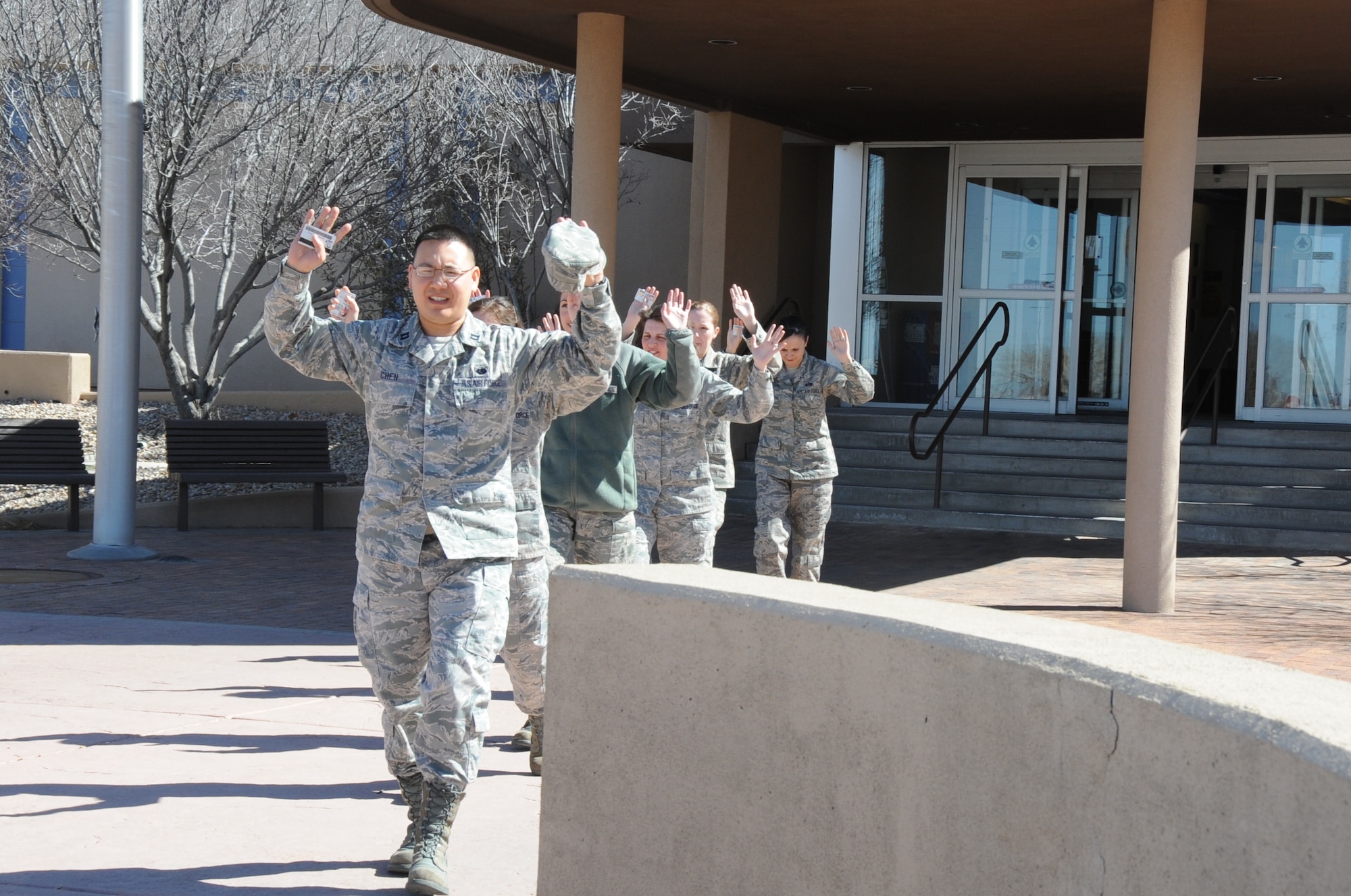 Airmen exit Building 20604 with their hands high during an active-shooter exercise. U.S. Air Force  Photo by Dennis Carlson