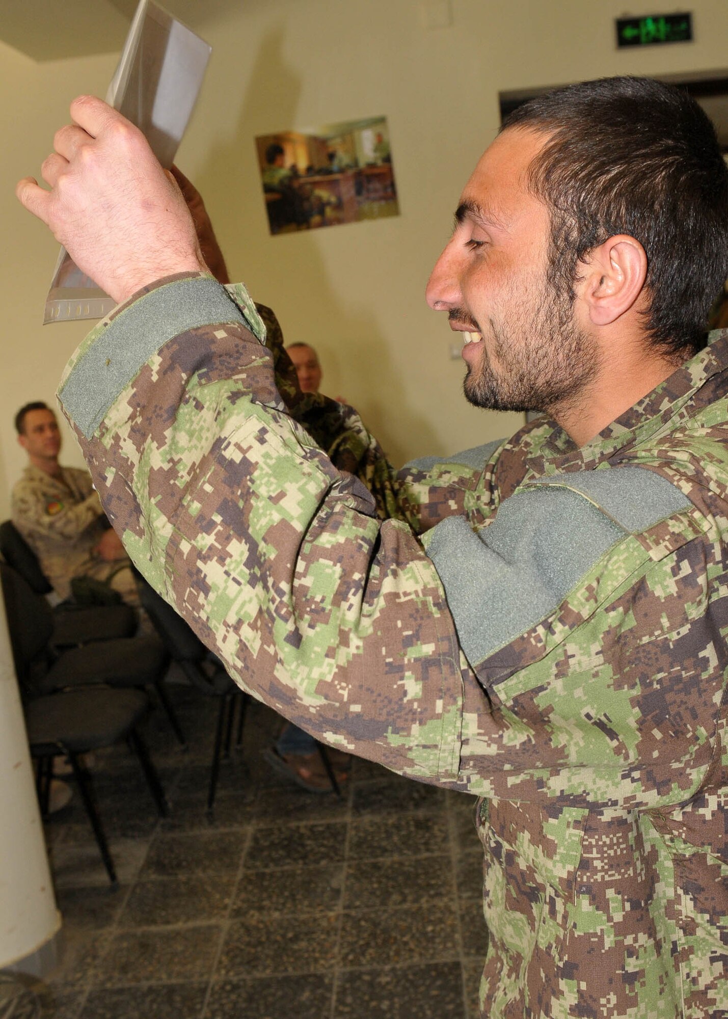 KABUL, Afghanistan - An Afghan Air Force member presents his graduation certificate at the Pohantoon-e-Hawayee, The Afghan Air Force's "Big Air School", on the Afghan Air Force base in Kabul, Afghanistan March 17. (U.S. Navy photo by Mass Communications Specialist 3rd Class Jared E. Walker)