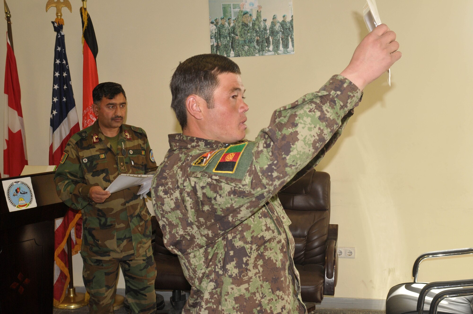 KABUL, Afghanistan - An Afghan Air Force member presents his graduation certificate at the Pohantoon-e-Hawayee, The Afghan Air Force's "Big Air School", on the Afghan Air Force base in Kabul, Afghanistan March 17. (U.S. Navy photo by Mass Communications Specialist 3rd Class Jared E. Walker)