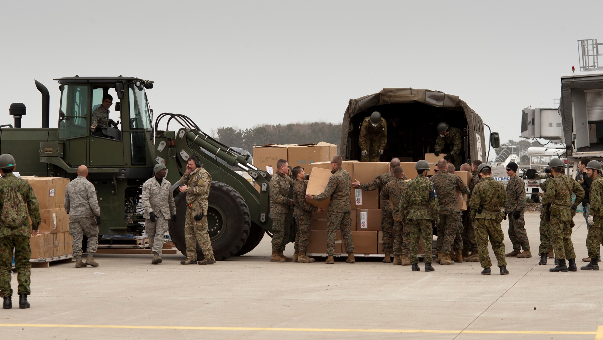 Airmen, Marines and Japan Ground Self-Defense Force soldiers load cargo onto a JGSDF truck at Sendai Airport, Japan, March 20. Since the reopening of Sendai Airport March 16, humanitarian aid supporting Operation Tomodachi has been able to be airlifted in more quickly and directly. (U.S. Air Force photo/Staff Sgt. Samuel Morse)