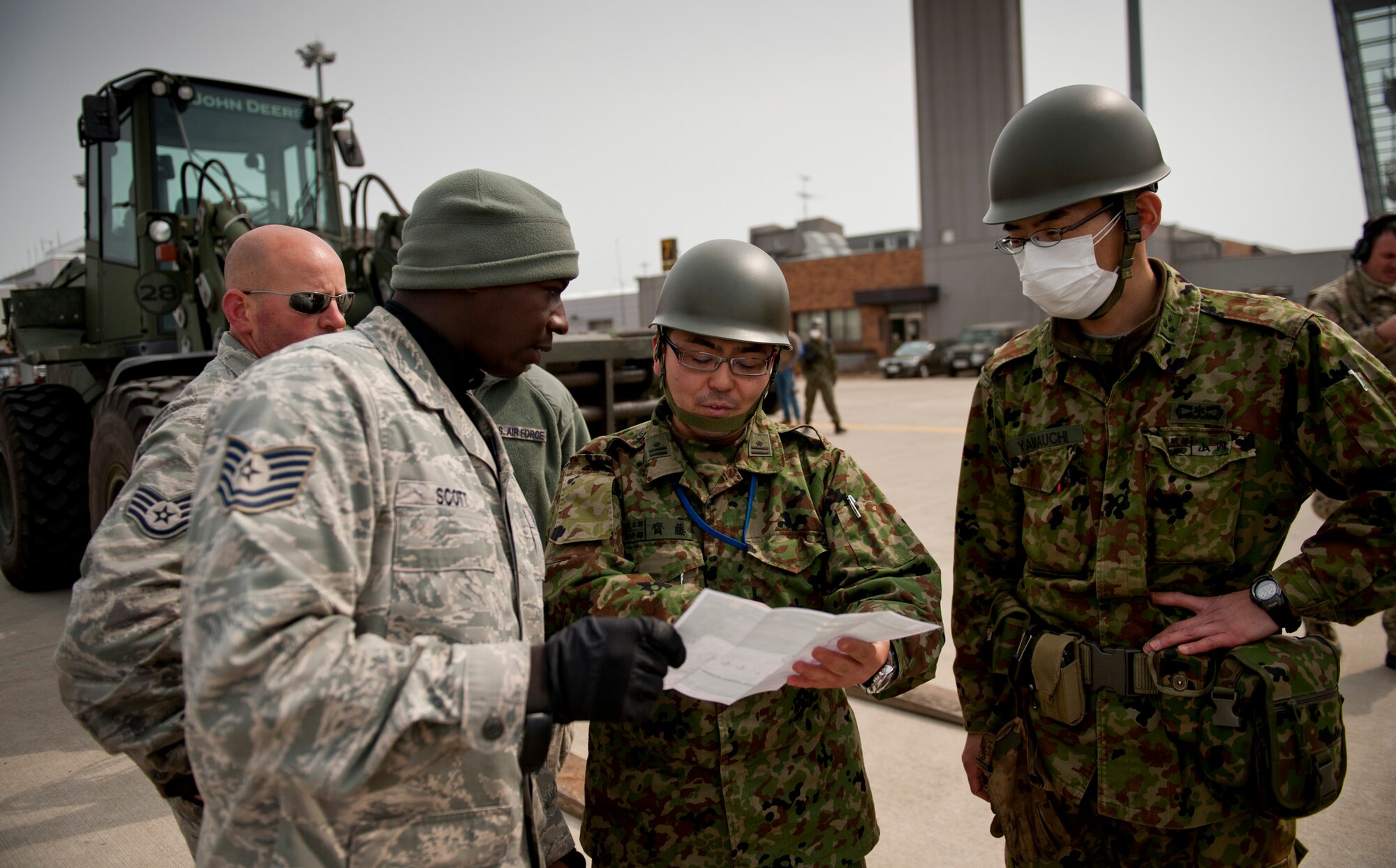 Tech. Sgt. Eugine Scott from Misawa Air Base, Japan, acting as a Japanese translator, coordinates cargo movement with members of the Japan Ground Self-Defense Force at Sendai Airport, Japan, March 20. Sendai Airport has become a main hub for bringing humanitarian aid to those affected by the earthquake and tsunami from March 11. (U.S. Air Force photo/Staff Sgt. Samuel Morse)