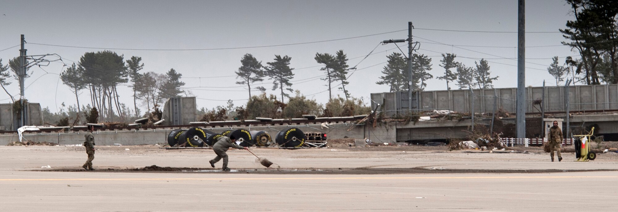Members of the 353rd Special Operations Group from Kadena Air Base, Japan, shovel mud off the flightline at Sendai Airport March 20. In addition to managing flightline operations, the Airmen from the 353rd SOG have been clearing additional space to accommodate more and larger aircraft in the future. The 320th STS and 353rd SOG are supporting U.S. military efforts to provide assistance to Japan following the March 11 earthquake and tsunami. (U.S. Air Force photo/Staff Sgt. Samuel Morse)