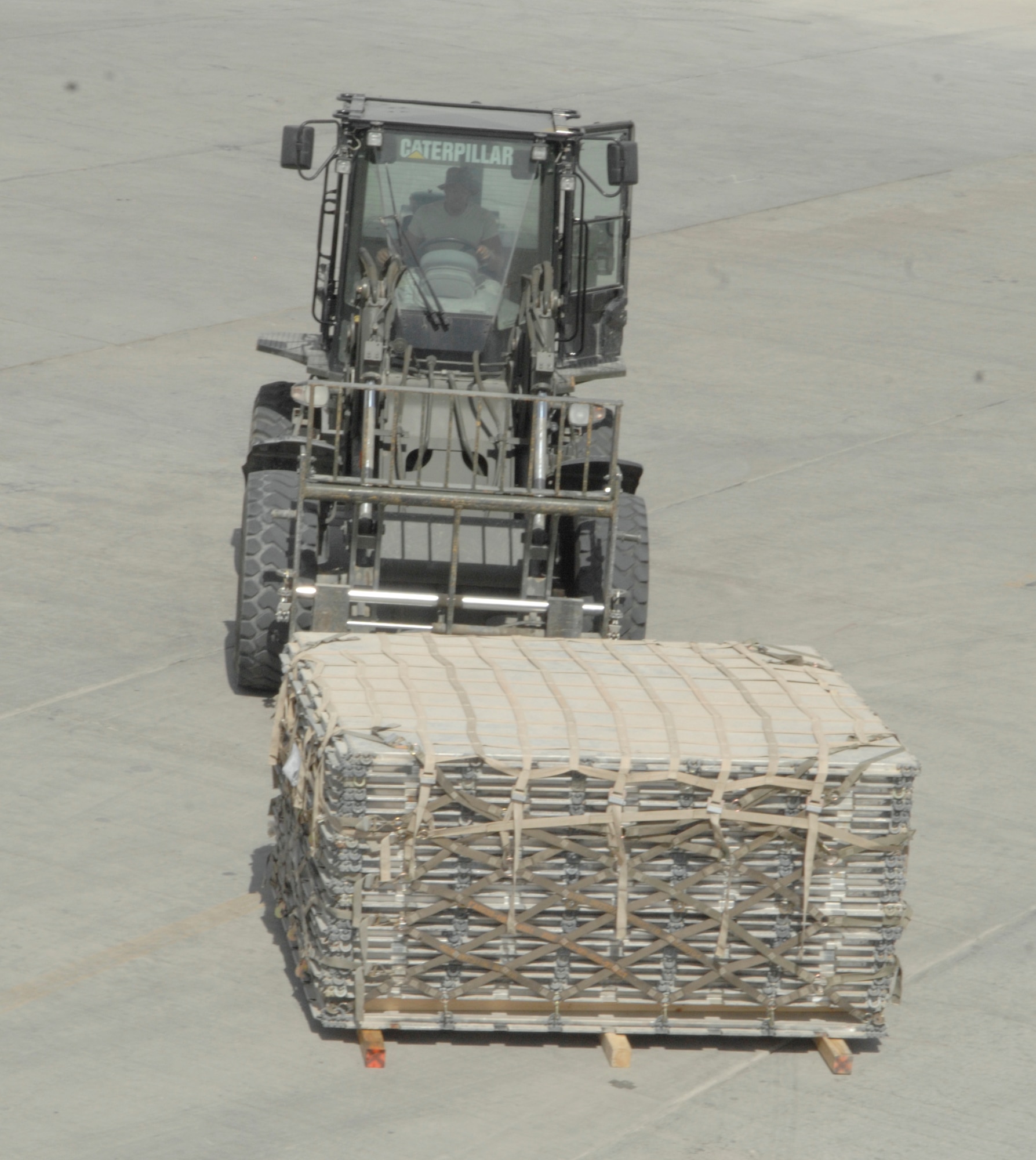 A member of the 455th Expeditionary Aerial Port Squadron moves a pallet from the cargo yard to be placed on a plane. The 455th EAPS is the busiest aerial port in the Department of Defense. (U.S. Air Force photo/Senior Airman Amber R. Kelly-Herard) 