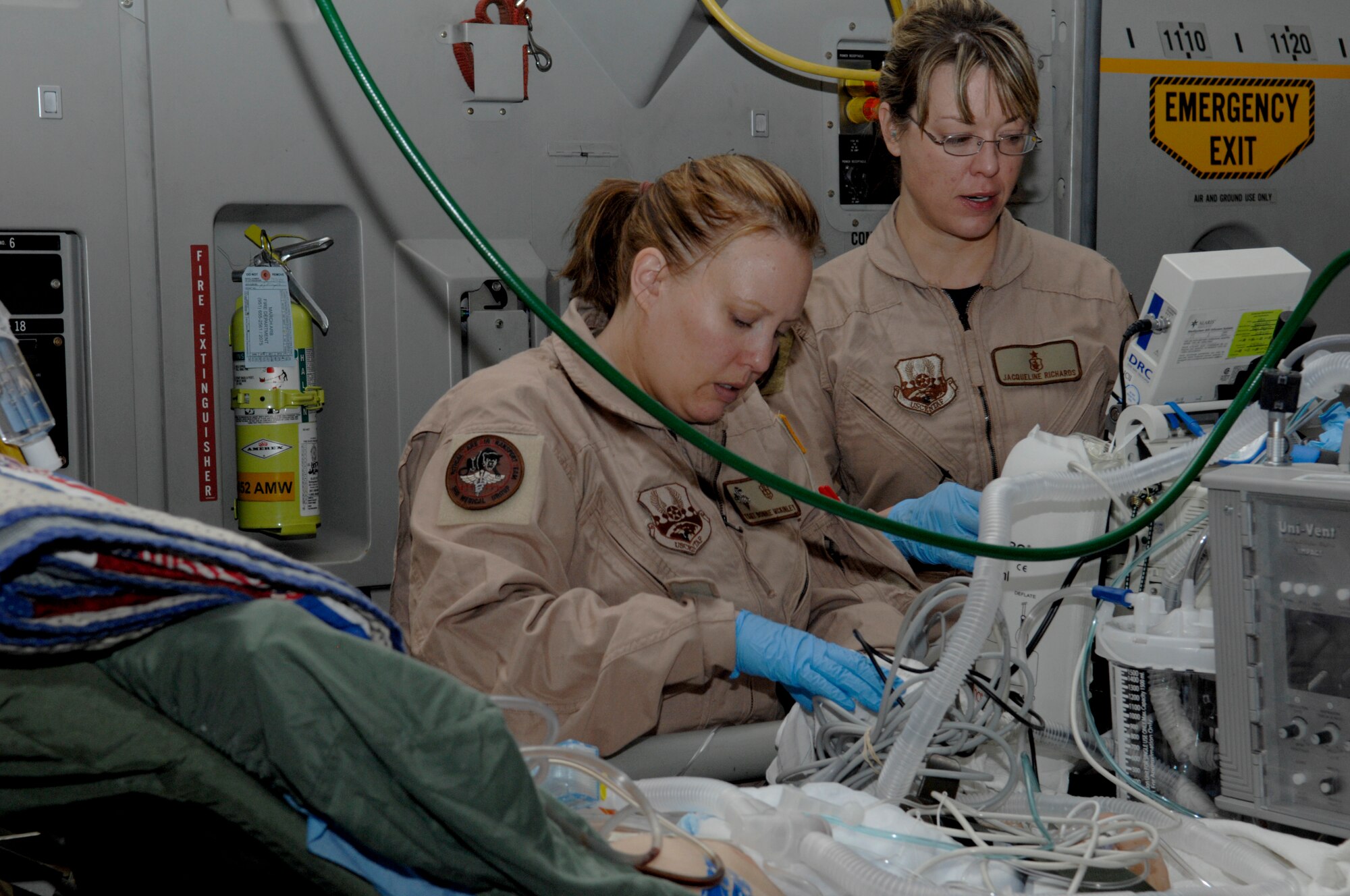 Capt. Jacquline Richards and Tech. Sgt. Bonnie McLauley, both members of a critical care team, transfer a patient from the Craig Joint Theater Hospital, Bagram Airfield, Afghanistan, to a plane enroute to Landstuhl Medical Center, Germany. The critical care team stays with a patient until they land at the hospital and transfer the patient's information to the receiving doctors. (U.S. Air Force photo/Senior Airman Amber R. Kelly-Herard) 