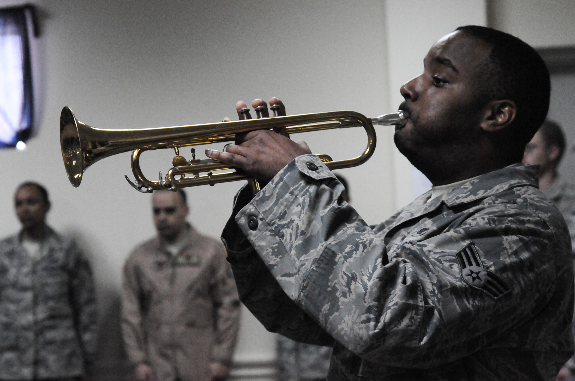 Senior Airman Samuel Bunting, 386th Expeditionary Communications Squadron, plays "Taps" during a memorial service March 19 at an undisclosed location in Southwest Asia. The 386th Air Expeditionary Wing held a memorial service to remember the life of Senior Airman Michael J. Hinkle II, 24, who died from a non-combat related incident March 16. (U.S. Air Force photo by Staff Sgt. Patrice Clarke)