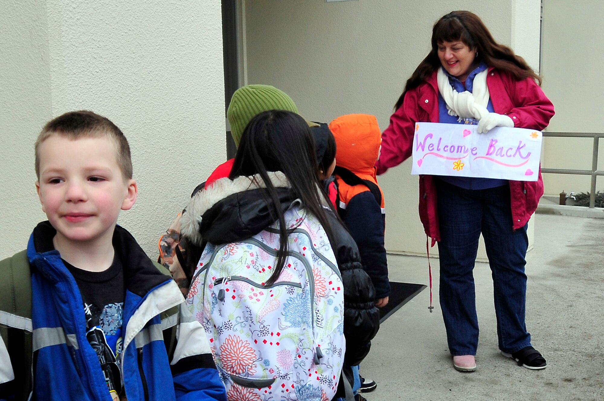 MISAWA AIR BASE, Japan -- Leigh Fox, school counselor, welcomes back the students at Sollars Elementary School Mar. 21. Base schools are back in session with all bus routes running and classes starting at the normal times. Students have been out since the school lost power after the earthquake that shook the northern coast of Japan Mar. 11. (U.S. Air Force photo by Staff Sgt. Marie Brown\Released)