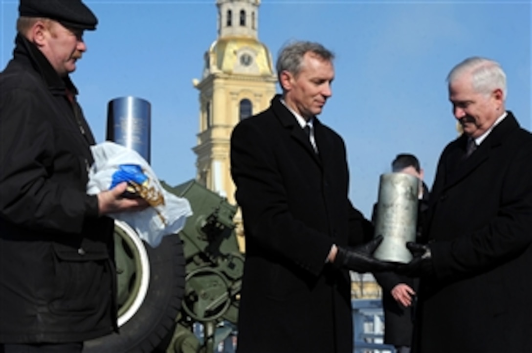 Director of the Central Naval Museum Russian Navy Capt. Andrey Lyalin presents Secretary of Defense Robert M. Gates with the 122mm shell following Gates' firing of the "Noon Cannon" during a tour of the Peter and Paul Fortress in St. Petersburg, Russia, on March 21, 2011.  