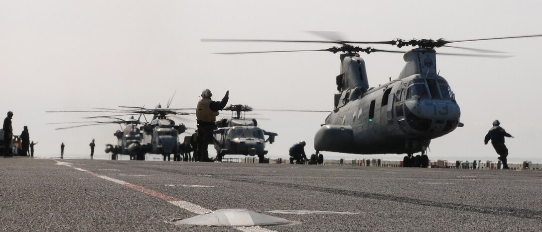 Sailors assigned to the forward-deployed amphibious assault ship USS Essex (LHD 2) prepare to launch helicopters  loaded with humanitarian assistance and disaster relief supplies. USS Essex, USS Harpers Ferry (LSD 49) and USS Germantown (LSD 42) with the embarked 31st Marine Expeditionary Unit are currently operating off the coast of Hachinohe in northeastern Japan in support of Operation Tomodachi.
