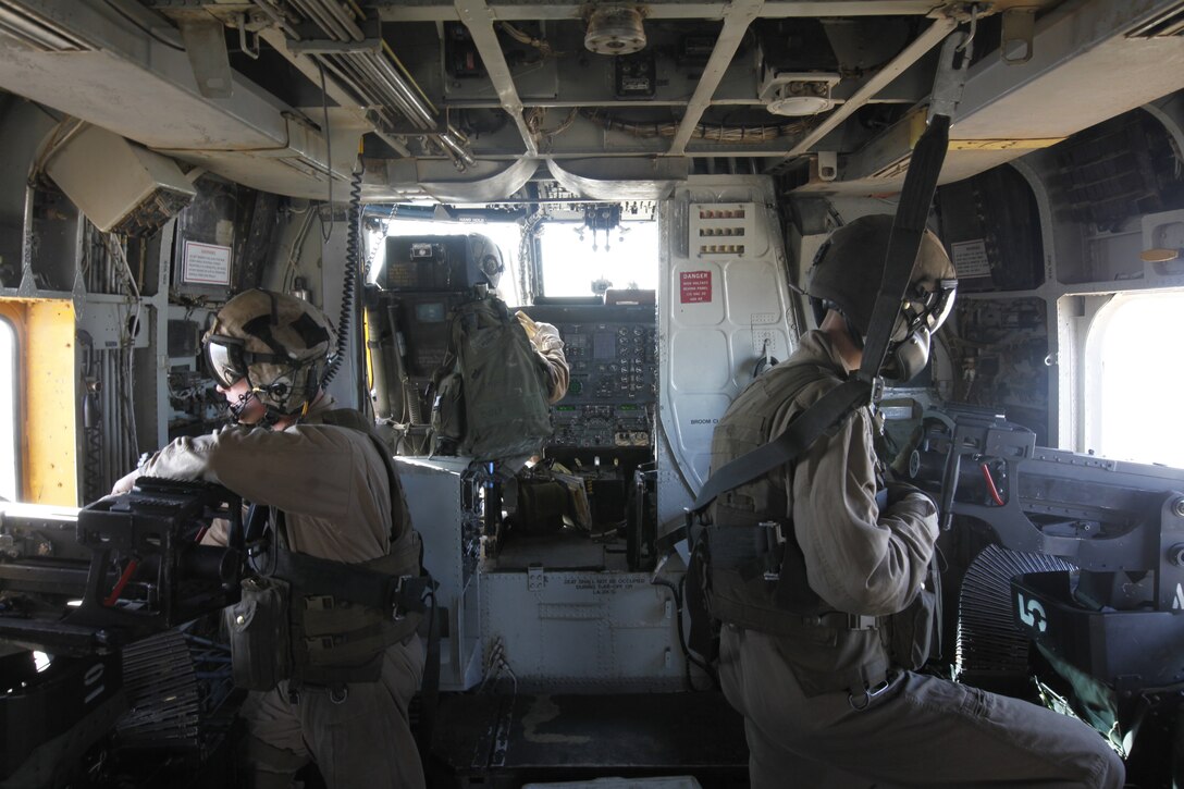 Gunnery Sgt. Shane Miller (left) and Sgt. Benjamin R. Schlicht (right) man the guns on a CH-53D Super Stallion during Operation Walkman's Fury, a tactical resupply mission designed to aid Marines of 2nd Battalion, 3rd Marine Regiment with their operations in southern Afghanistan, March 22., Miller is an aerial observer and Schlicht is a CH-53D crew chief with HMH-463.