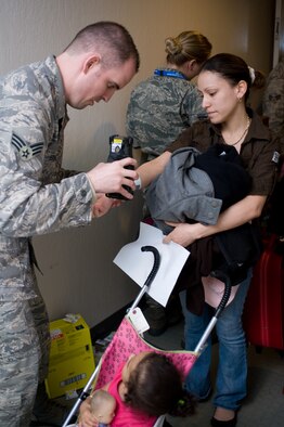 Jennifer Balares has her i.d. bracelet scanned by Senior Airman Kyle Ferlane after arriving at Travis AFB, Calif., on March 22. Balares and her three children were part of approximately 240 military  family members who returned to the U.S. from Japan following the March 11, 2011 earthquake and tsunami that hit the island nation. (Photo by Ken Wright)