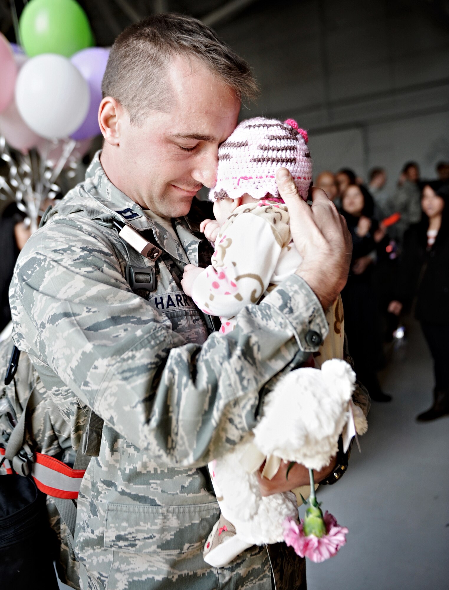 MOUNTAIN HOME AIR FORCE BASE, Idaho -- Capt. Bryan Harr, 726th Air Control Squadron, hugs his baby daughter for the first time after returning home March 19. Nearly 200 personnel were reunited with family and friends after spending more than six months deployed to Southwest Asia in support of Operation New Dawn.  (U.S. Air Force photo by Airman 1st Class Renishia Richardson)