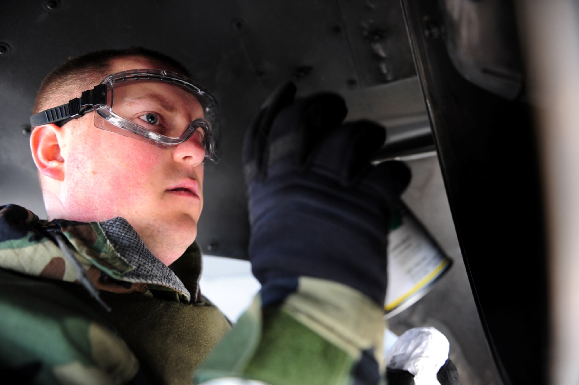 Senior Airman Matthew McKay, 19th Equipment Maintenance Squadron nondestructive inspections journeyman, applies a penetrant on the rear turbine casing of a C-130 during an exercise, March 15, 2011 at Little Rock Air Force Base, Ark. Senior Airman McKay inspects the casing with ultraviolet light after applying the penetrant to reveal cracks. (Photo by U.S. Air Force Senior Airman Jim Araos)