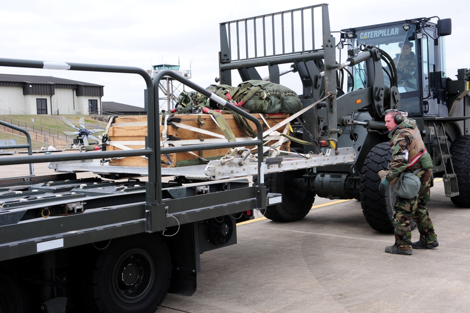Staff Sgt. Mark Cromwell  guides a forklift driven by Staff Sgt. Jamie Screeton during an exercise March 15, 2011, at Little Rock Air Force Base, Ark. The 19th Logistics Readiness Squadron aerial delivery supervisors exercised their ability to deploy and operate in a hostile environment  . (Photo by U.S. Air Force Senior Airman Jim Araos)