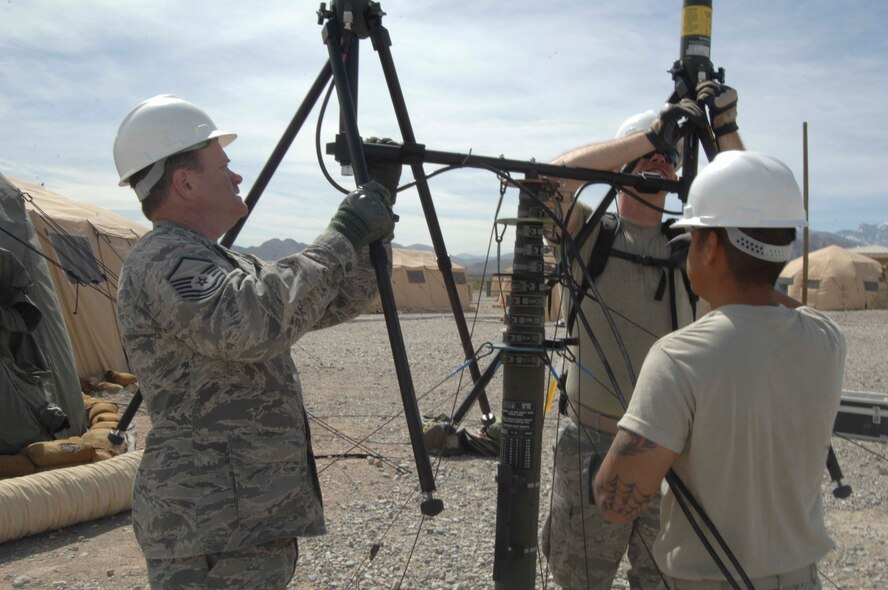 NEVADA TEST AND TRAINING RANGE, Nev.-- Airmen from the 822nd Base Defense Squadron communication division take down the main antenna used March 16, 2011, after the end of DESERT EAGLE. The antenna’s purpose was to provide reachback capabilities from the 822nd BDS members participating in the exercise to their home station of Moody Air Force Base, Ga. (U.S. Air Force photo/Airman 1st Class Brigitte N. Brantley-Sisk)(RELEASED)