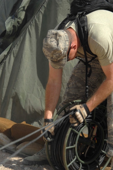 NEVADA TEST AND TRAINING RANGE, Nev.-- Staff Sgt. Billy Austin, 822nd Base Defense Squadron data communications NCO in charge from Moody Air Force Base, Ga., gathers wire after the end of DESERT EAGLE March 16, 2011. During the exercise, American and British Airmen were able to successfully communicate vital information because of the equipment maintained by the communication division. (U.S. Air Force photo/Airman 1st Class Brigitte N. Brantley-Sisk)(RELEASED)