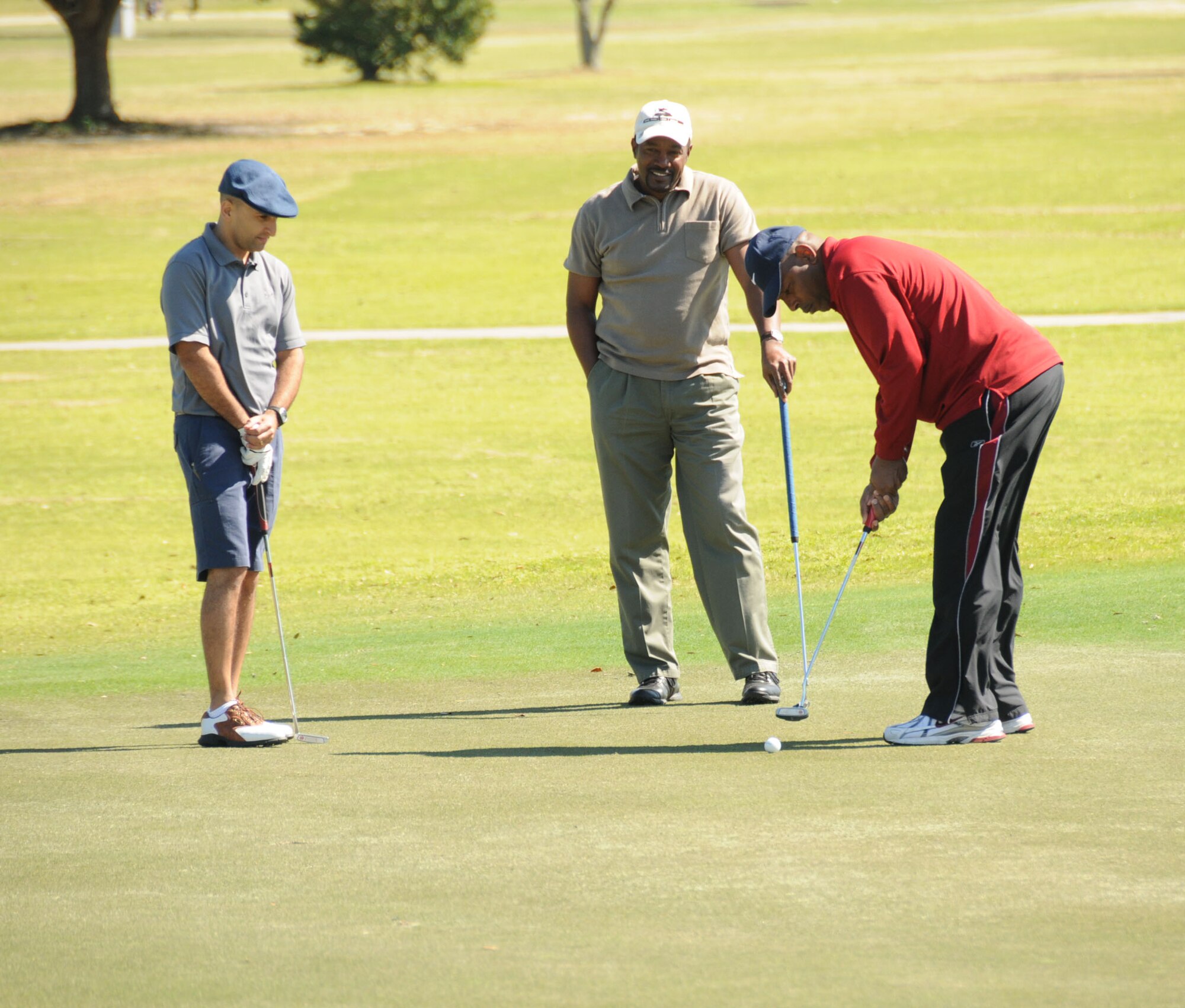 From left, Richie Frias, 81st Medical Support Squadron, and James Cook, 81st Training Support Squadron, watch Levi Brown, 334th Training Squadron, putt on Hole 9 during Friday’s African-American Heritage Committee Golf Tournament at Bay Breeze Golf Course. The winning team, which included Kenneth Powell, Matthew Blish and Robert Fried from the 338th TRS and Ronald Dupree from the 332nd TRS, shot a 65 in the four-person scramble format. The tournament raised $928 for the AAHC’s Col. Lawrence E. Roberts Scholarship Fund.  (U.S. Air Force photo by Kemberly Groue)