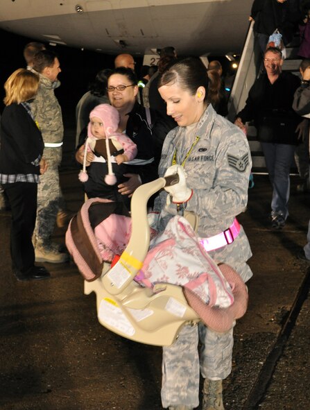 Staff Sgt. Katie Speer, 60th Air Mobility Wing command chief executive, carries a child off a military-chartered flight March 22, 2011, at Travis Air Force Base, Calif. Approximately 500 passengers arrived at Travis Air Force Base in support of Operation Pacific Passage. On March 17, 2011, the Office of the Secretary of Defense approved voluntary assisted departures to the United States for family members residing in Japan. These flights will continue for the foreseeable future to accommodate the needs of our service member’s families. (U.S. Air Force Photo/Airman 1st Class Michael Battles)