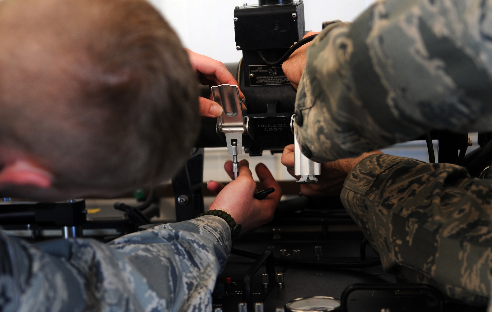 MOODY AIR FORCE BASE, Ga. -- Senior Airman Dustin Stinnett, 23rd Equipment Maintenance Squadron precision guided munitions crewmember, and Tech. Sgt. David Edwards, 23rd EMS precision guided munitions production supervisor, secure an AIM-9 Sidewinder air-to-air missile onto a guidance control section test set March 22. To ensure an accurate functional inspection, the AIM-9 must be mounted and fastened. (U.S. Air Force photo/Airman 1st Class Douglas Ellis)(RELEASED)
