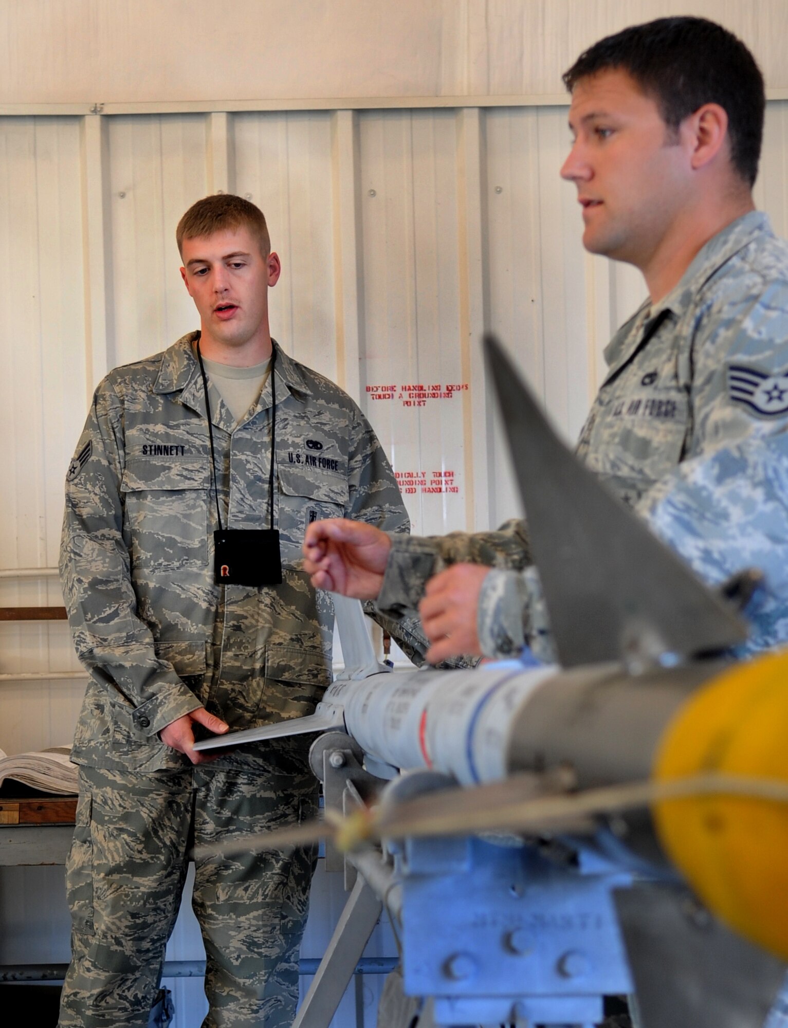 MOODY AIR FORCE BASE, Ga. -- Senior Airman Dustin Stinnett, 23rd Equipment Maintenance Squadron precision guided munitions crewmember, and Staff Sgt. David Sain, 23rd EMS precision guided munitions crewchief, prepare to remove the AIM-9 Sidewinder air-to-air missile head March 22. After removing the AIM-9 head, the precision guided munitions flight used a guidance control section test set to run a functional check on it. (U.S. Air Force photo/Airman 1st Class Douglas Ellis)(RELEASED)
