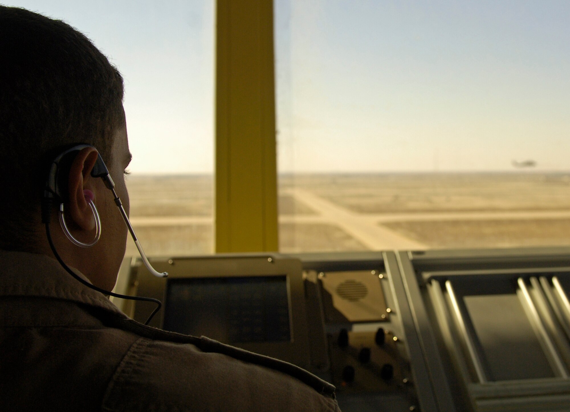An Iraqi Air Force air traffic control trainee directs a pair of UH-60 Blackhawk helicopters as they prepare to land on the airfield Feb. 3. U.S and Iraqi student controllers handle 2,500 operations that deliver more than 400 cargo tons and 2,500 passengers each month.  (U.S. Air Force photo)