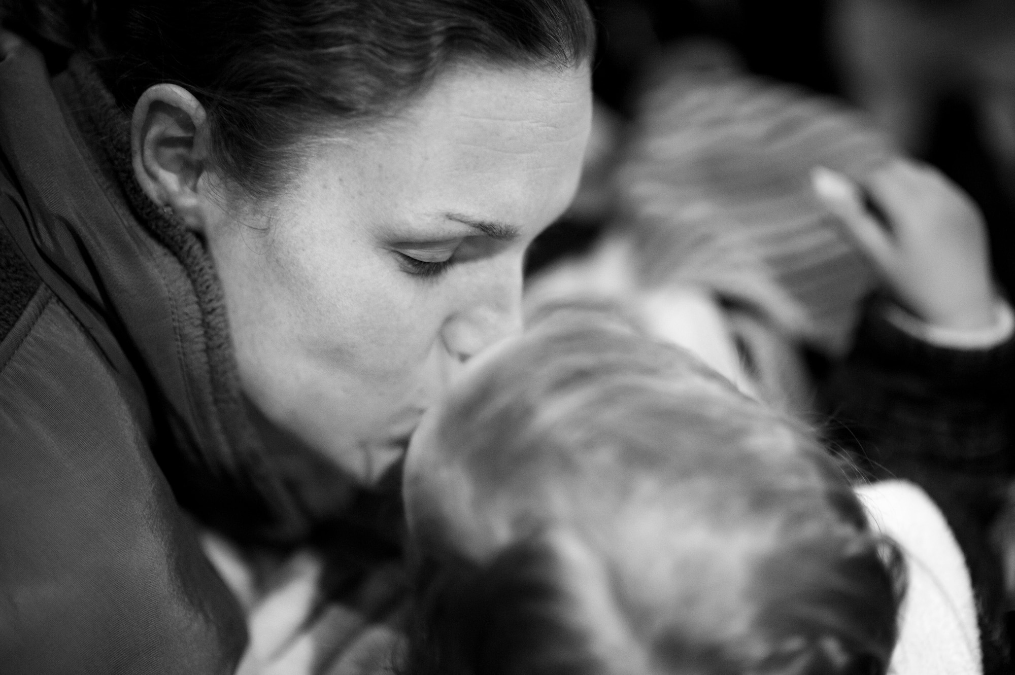 YOKOTA AIR BASE, Japan -- 1st Lt. Tamara Grimaud, 374th Surgical Operations Squadron, kisses her daughter aboard a C-130H Hercules here March 22. Military mothers and those expecting were given the option to relocate to Kadena Air Base, Japan, so heavily tasked medical staff can focus on those affected by the earthquake and tsunami. (U.S. Air Force photo/Staff Sgt. Samuel Morse)