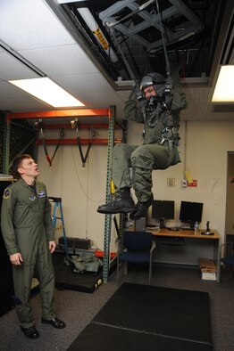Capt. James White, 509th Operations Support Squadron aircrew flight equipment officer, instructs Andrew Swan during egress training at Whiteman Air Force Base March 19. Andrew visited Whiteman to be an Airman for a day as part of a Dream Factory project. (U.S. Air Force photo by Staff Sgt Lauren Padden)(Released) 
