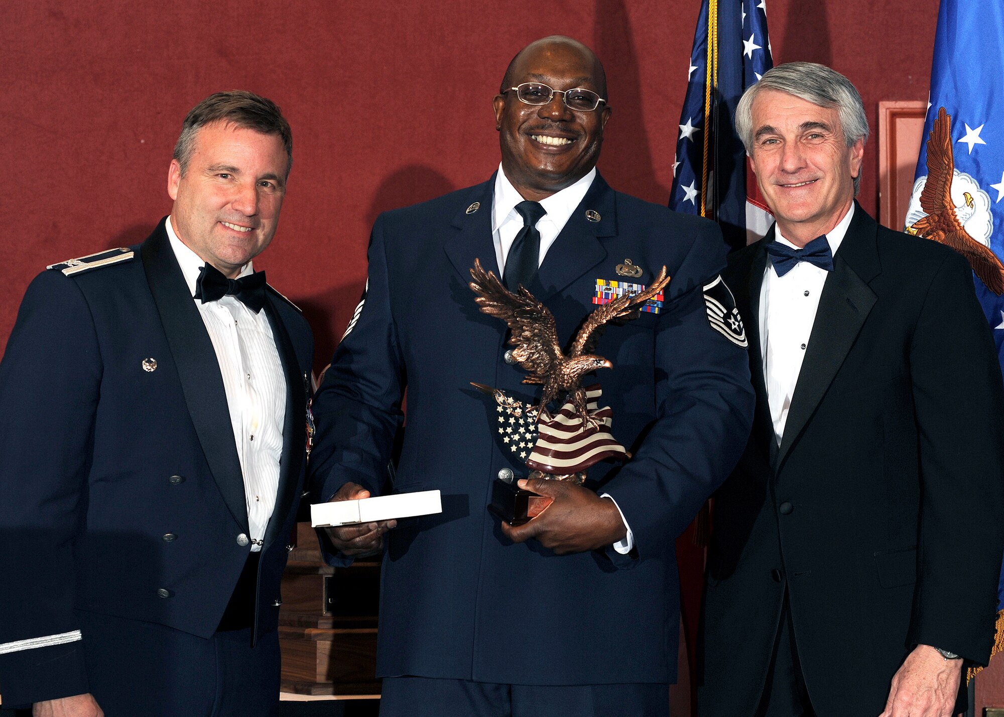 Master Sgt. Michael Goggins (center) accepts the award for 310th Space Wing Civilian Supervisor Category II of the Year from 310th Space Wing Vice Commander Mark Hustedt (left) and Chamber of Commerce President Brian Binn (right) at the wing awards banquet on March 5, 2011 at the Antlers Hilton in Colorado Springs, Colo. (U.S. Air Force photo by Dave Ahlschwede)