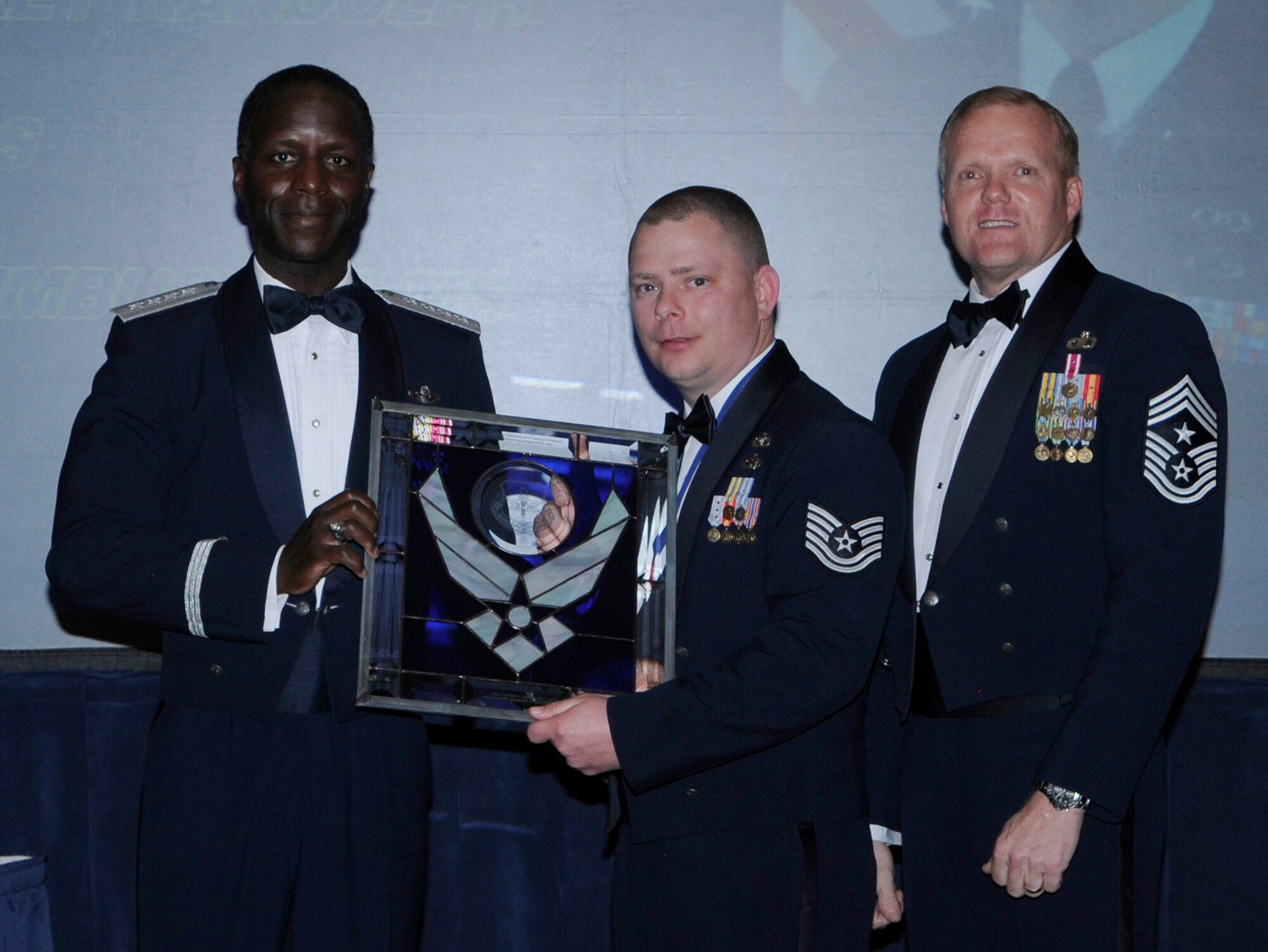 General Edward Rice, Air Education And Training Command commander and Chief Master Sergeant James Cody, Air Education and Training Command , command chief presents Honor Guard Of The Year Manager award to Technical Sergeant Jeffrey Randolph, 14 Operational Support Squadron, Columbus Air Force Base, Mississippi.  Ceremony was held at the Parr Officer Club at Randolph Air Force Base, Texas on March 18.(U.S. Air Force photo/by Don Lindsey).
