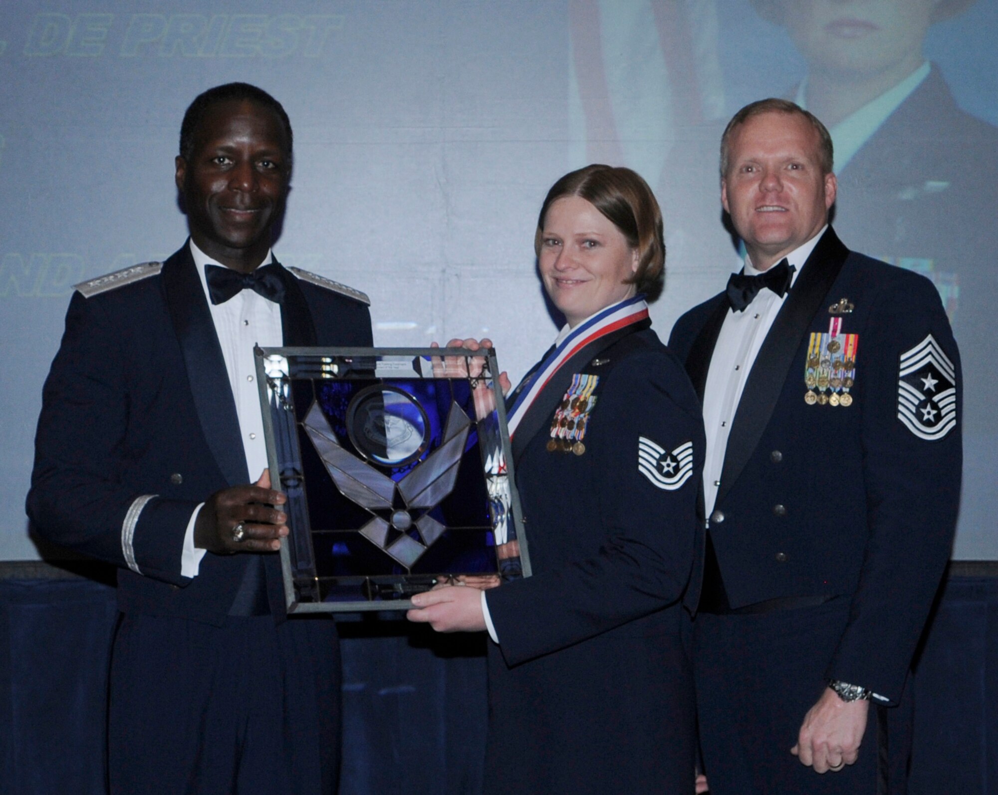 General Edward Rice, Air Education And Training Command commander and Chief Master Sergeant James Cody, Air Education and Training Command , command chief presents Air Education and Training Command Military Training Instructor Of The Year award to Technical sergeant Julie D. De Priest, 323 training squadron, Lackland Air Force Base, Texas.  Ceremony was held at the Parr Officer Club at Randolph Air Force Base, Texas on March 18.(U.S. Air Force photo/by Don Lindsey).
