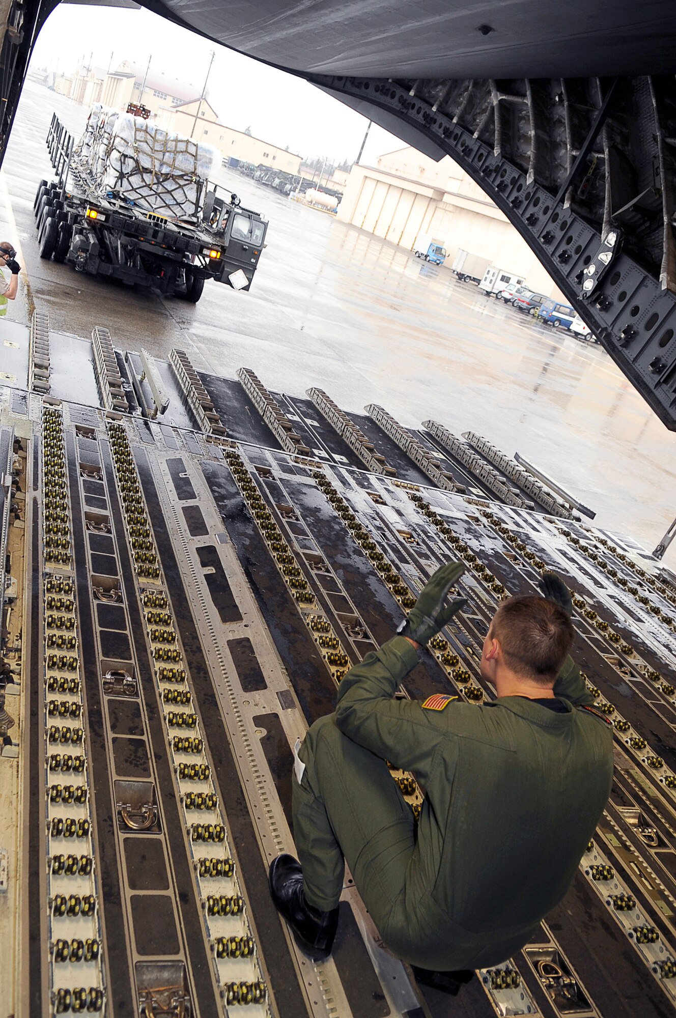 As part of Operation Tomodachi, Staff Sgt. Chris Baker guides a K-loader with humanitarian supplies behind a C-17 Globemaster III March 21, 2011, at Yokota Air Base, Japan. Crews unloaded the water and other relief items at Sendai Airport as American forces worked closely with their Japanese counterparts to aid the people of Japan in the aftermath of an earthquake that hit Japan March 11. "Tomodachi" is a Japanese word meaning friends. Sergeant Baker is a member of the 535th Airlift Squadron at Joint Base Pearl Harbor-Hickam, Hawaii. (U.S. Air Force photo by/Master Sgt. Jeromy K. Cross) 