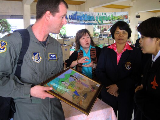 Maj. Greg Richert accepts a thank-you gift on behalf of Cope Tiger Airmen who donated toys and school supplies to school children during a community outreach event March 18, 2011, in Korat, Thailand. Major Richert is the chief of aerospace medicine at 13th Air Force, Joint Base Pearl Harbor-Hickam, Hawaii, and the medical lead for Exercise Cope Tiger 2011, an annual, multilateral, joint field training exercise being conducted at Korat and Udon Thani Royal Thai Air Bases March 14 through 25. (U.S. Air Force photo/Capt. Kirsten R. Udd) 