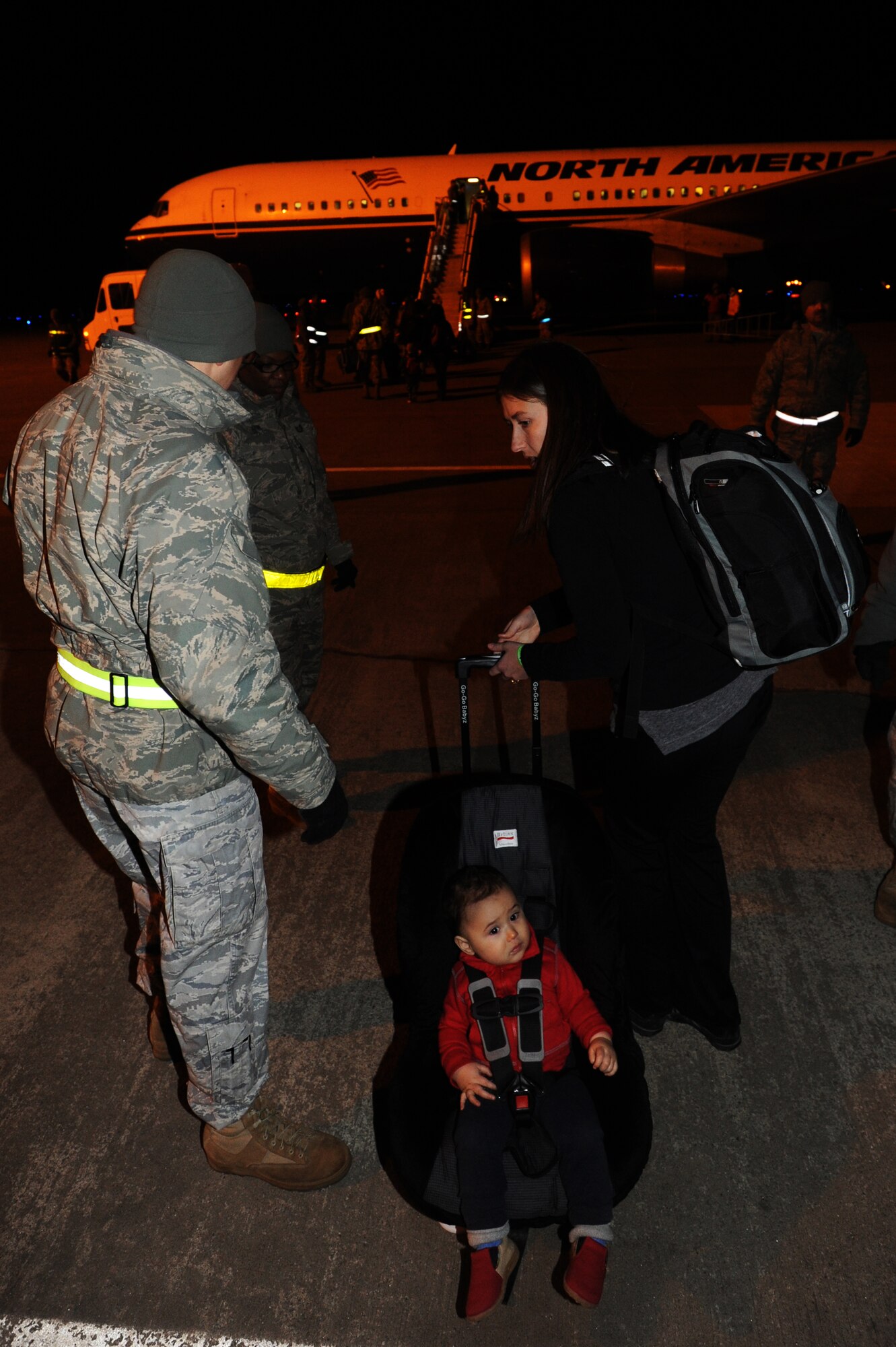 MISAWA AIR BASE, Japan -- On March 22, Kasey Haedge walks toward the B-767 with her 14 month old son Michael, they are part of the 240 family members that volunteered to return to the continental United States due to the recent earth quake and tsunami disaster.  The Defense Department authorized a voluntary departure of family members from Northern Japan due to the recent earth quake and tsunami disaster.  (U.S. Air Force Staff Sgt. April Quintanilla)