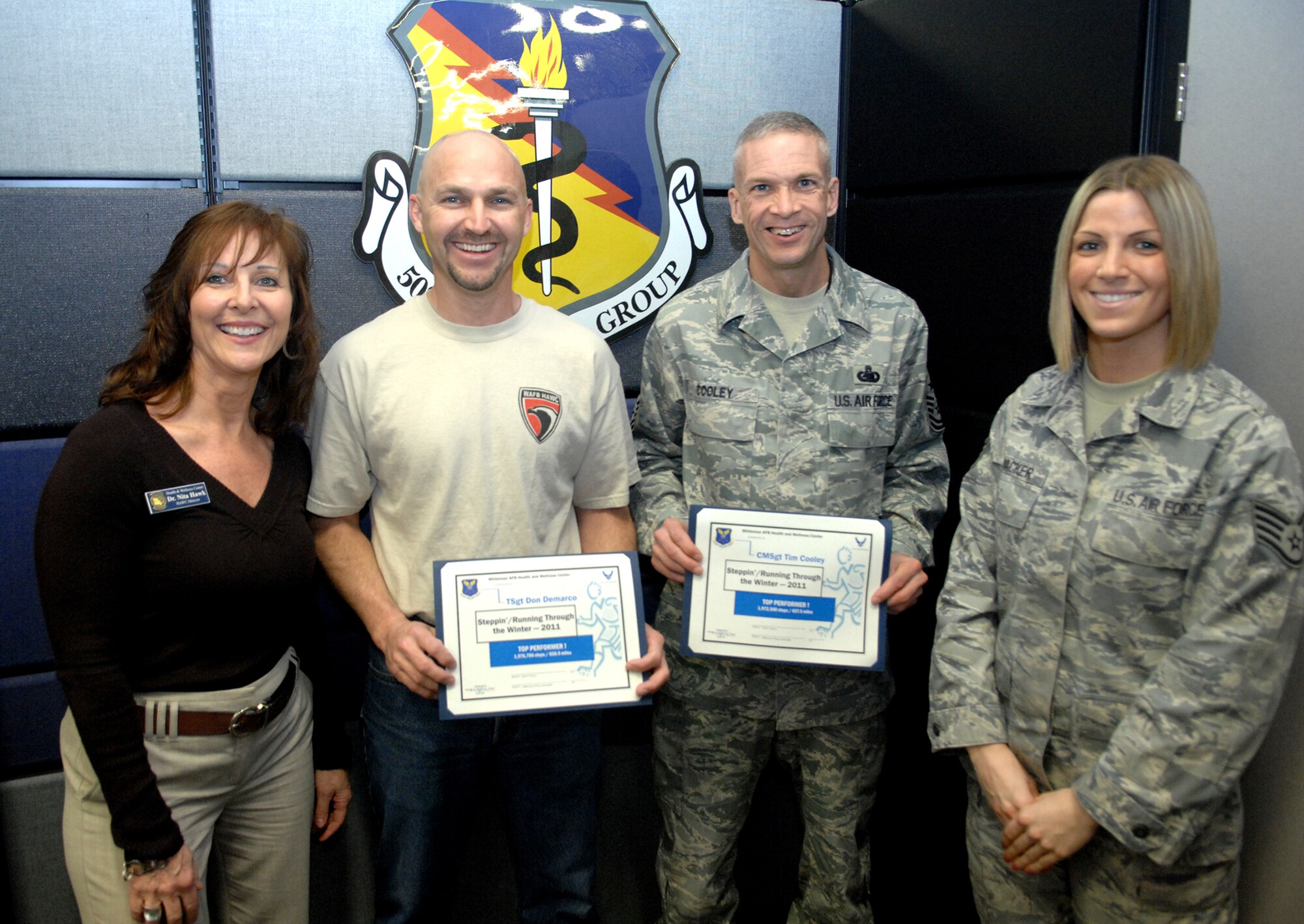 WHITEMAN AIR FORCE BASE, Mo. – (Left center) First-place winner Tech. Sgt. Don DeMarco, 442nd Fighter Wing Aircraft Maintenance Squadron aircraft mechanic, and runner up, Chief Master Sgt. Tim Cooley, 509th Bomb Wing command chief, receive certificates from the (left) Dr. Nita Hawk, 509th Operations Squadron health promotion director and fitness program manager, and (right) Staff Sgt. Heidi Wacker, 509th MDOS diet therapist NCO in charge, March 18.  The pedometer program, ‘stepping through the winter’ is designed to encourage the base populace to get physically active. (U.S. Air Force photo by Airman 1st Class Cody H. Ramirez) (Released)