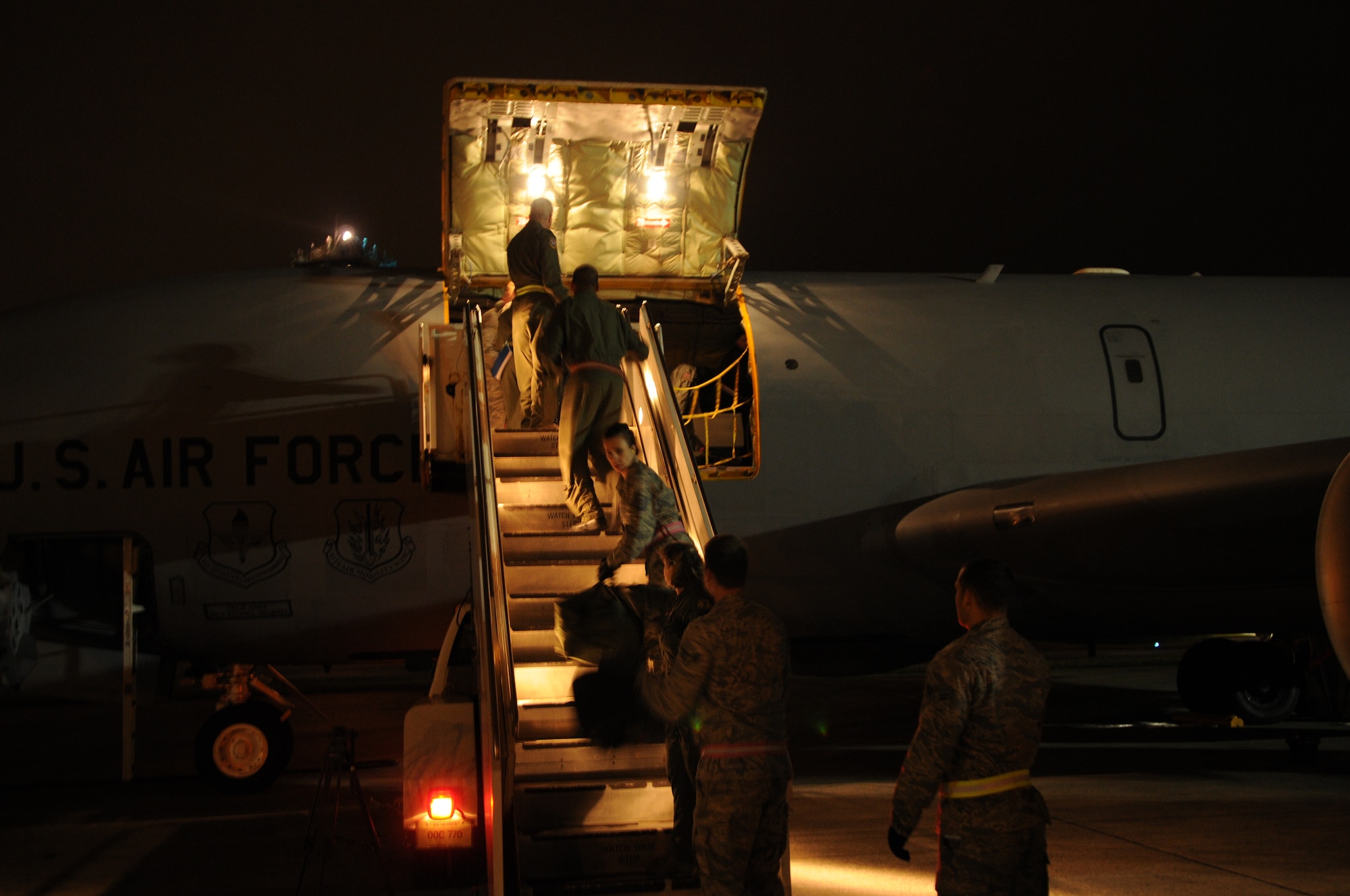 Kadena members unload bags of moms-to-be and their families off a KC-135 from mainland Japan to Kadena Air Base, Mar. 23. Members of the 18th Aeromedical Evacuation Squadron and the 909th Air Refueling Squadron were able to transport nine moms and their families to Okinawa, Japan. This option was an alternative for moms-to-be and their families flying back to the United States which is not advised after 35 weeks of pregnancy. (U.S. Air Force photo by Airman 1st Class Jarvie Z. Wallace)
