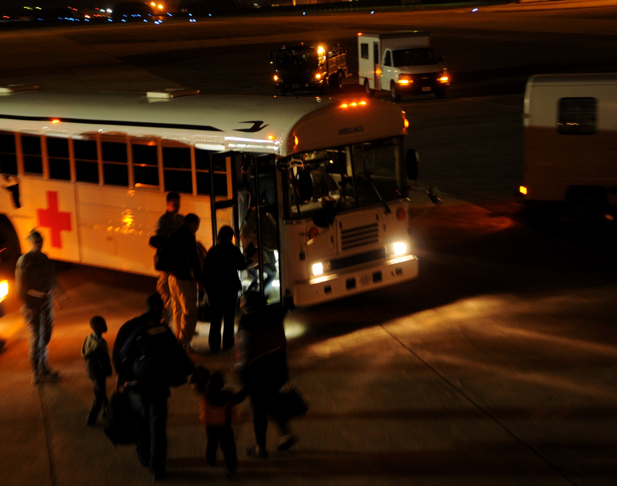 Pregnant mothers and their families prepare to board a medical bus after arriving on a KC-135 aircraft from Atsuki to Kadena Air Base, March 22. Members of the 18th Aeromedical Evacuation Squadron and the 909th Air Refueling Squadron were able to transport nine moms and their families to Okinawa, Japan. This option was an alternative to flying back to the United States which is not advised after 35 weeks of pregnancy.