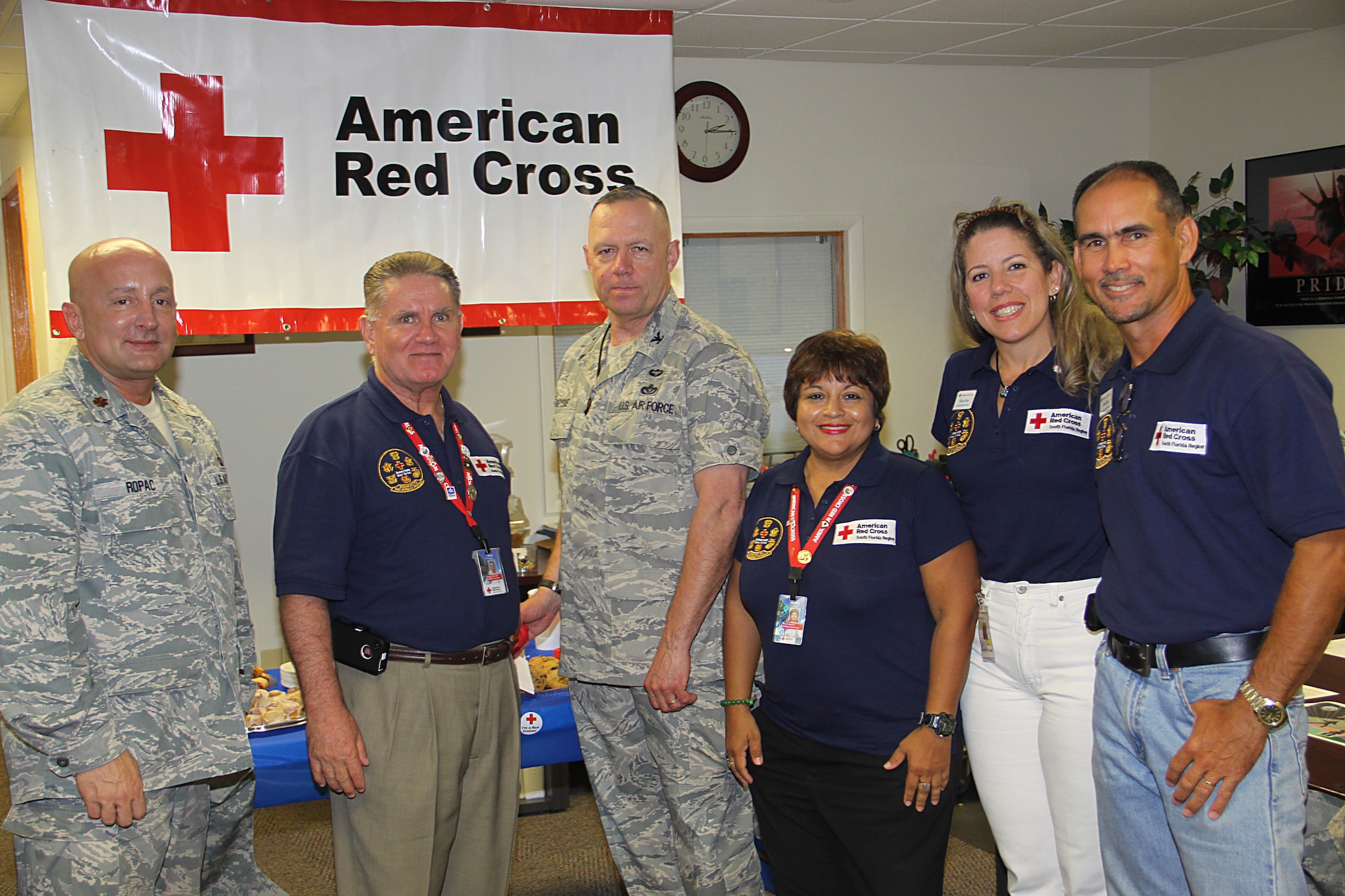 Colonel Elwin A. Rozyskie Jr., Commander of the 482d Mission Support Group and Major Richard C. Ropac, Deputy Commander of 482d Mission Support Group, pose for a photo with Red Cross Volunteers while attending the opening of the new American Red Cross support desk at Homestead Air Reserve Base on March 18. (U.S. Air Force photo by Airman 1st Class Jacob Jimenez/482d Fighter Wing Public Affairs)