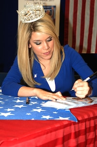 Ms. Teresa Scanlan, Miss America 2011, signs photographs at Langley Air Force Base, Va., March 21, 2011. Miss Scanlan dreams of becoming an attorney and eventually a judge or the President of the United States of America. (U.S. Air Force photo by Airman 1st Class Racheal Watson/Released)