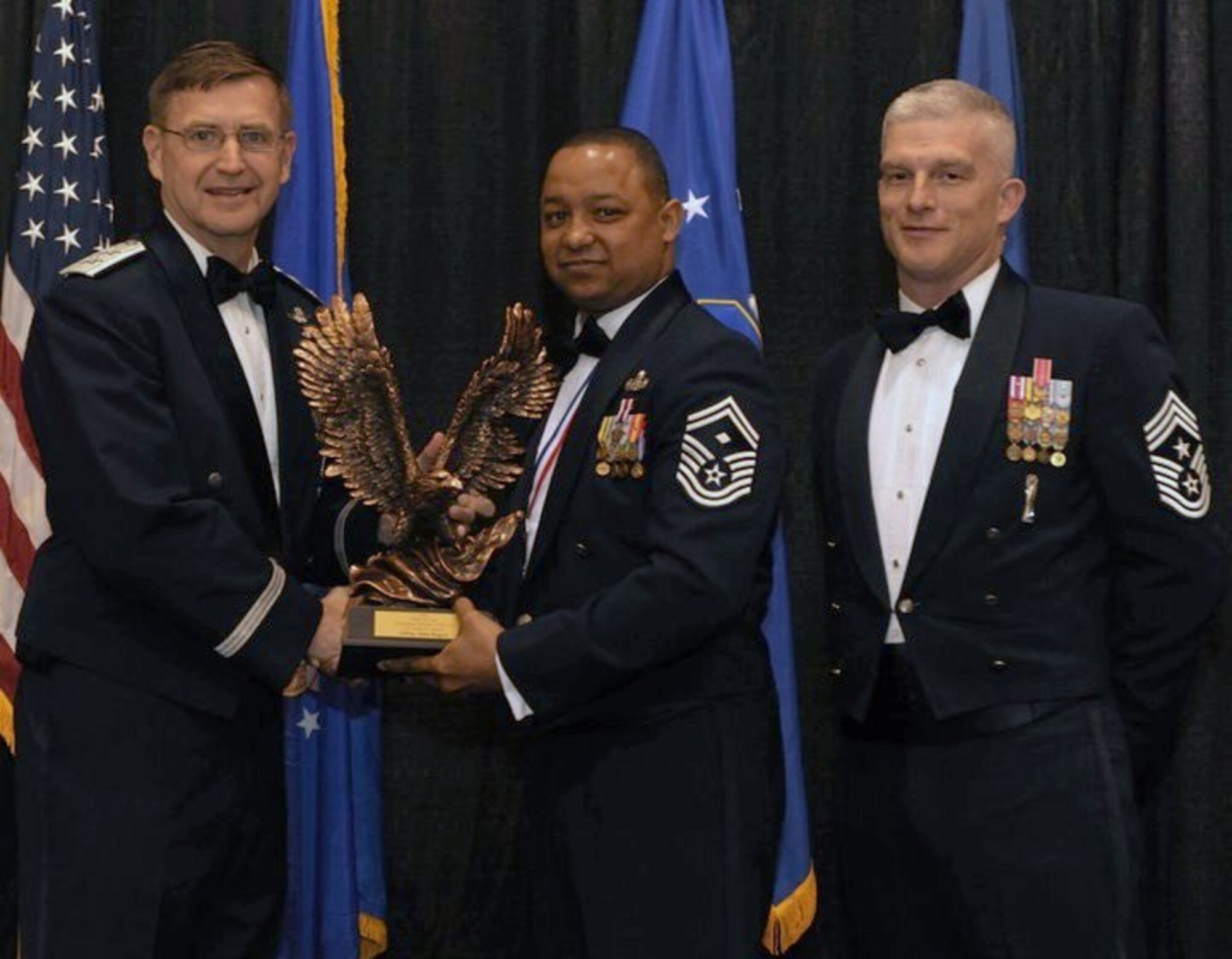 Maj. Gen. Stephen Hoog, Ninth Air Force commander, and Chief Master Sgt. Robert Brooks, 9 AF command chief, present Senior Master Sgt. John Rogers, 633d Security Forces Squadron first sergeant, with the First Sergeant of the Year award during the 2010 9 AF Outstanding Performer of the Year Awards Banquet at the James H. Rainwater Conference Center in Valdosta, Ga., March 10, 2011. Sergeant Rogers is the second consecutive Squadron shirt to win the 9 AF-level award. (Photo courtesy/Senior Master Sgt. John Rogers/RELEASED)