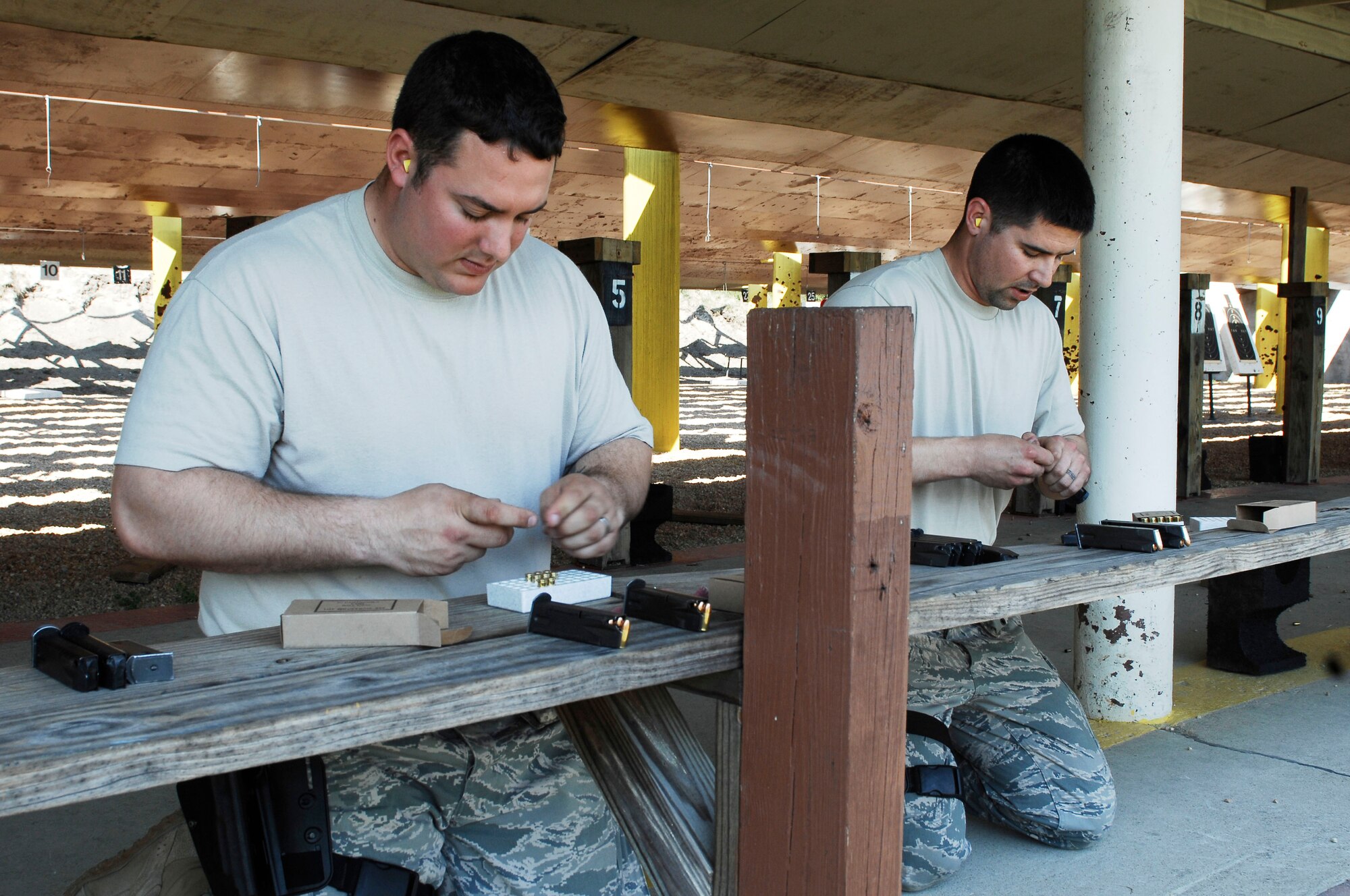 Staff Sgt. Chris Rocchio and Tech. Sgt. Adam Miller, 633d Security Forces squadron military working dog section, load weapons before participating in the marksmanship competition at Langley Air Force Base, Va., March 18, 2011.  Members participated in the first annual event to build cohesiveness between Joint Base Langley-Eustis military police. (U.S. Air Force photo by Airman 1st Class Kayla Newman/Released)
