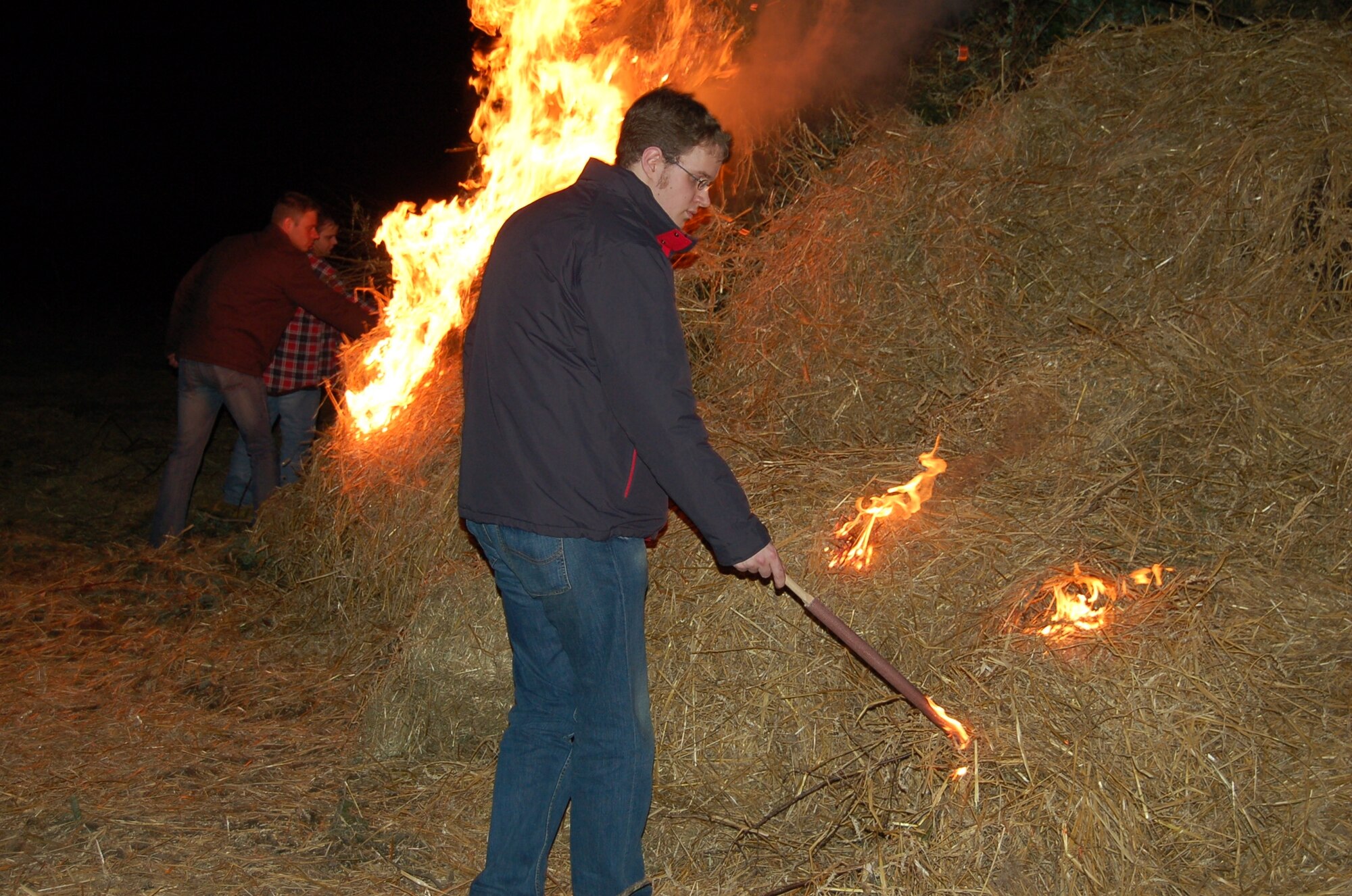 PREIST, Germany - A young man from the community of Preist, a community located outside of Spangdahlem, lights a bonfire. In the Eifel region the first Sunday of Lent is called “Huettensonntag,” Following an ancient tradition townspeople believe that by lighting huge bonfires they can chase away winter spirits. Using straw and brushwood, the young people of the village built a so called “hut” that set on fire in the evening. (U.S. Air Force Photo/Iris Reiff)