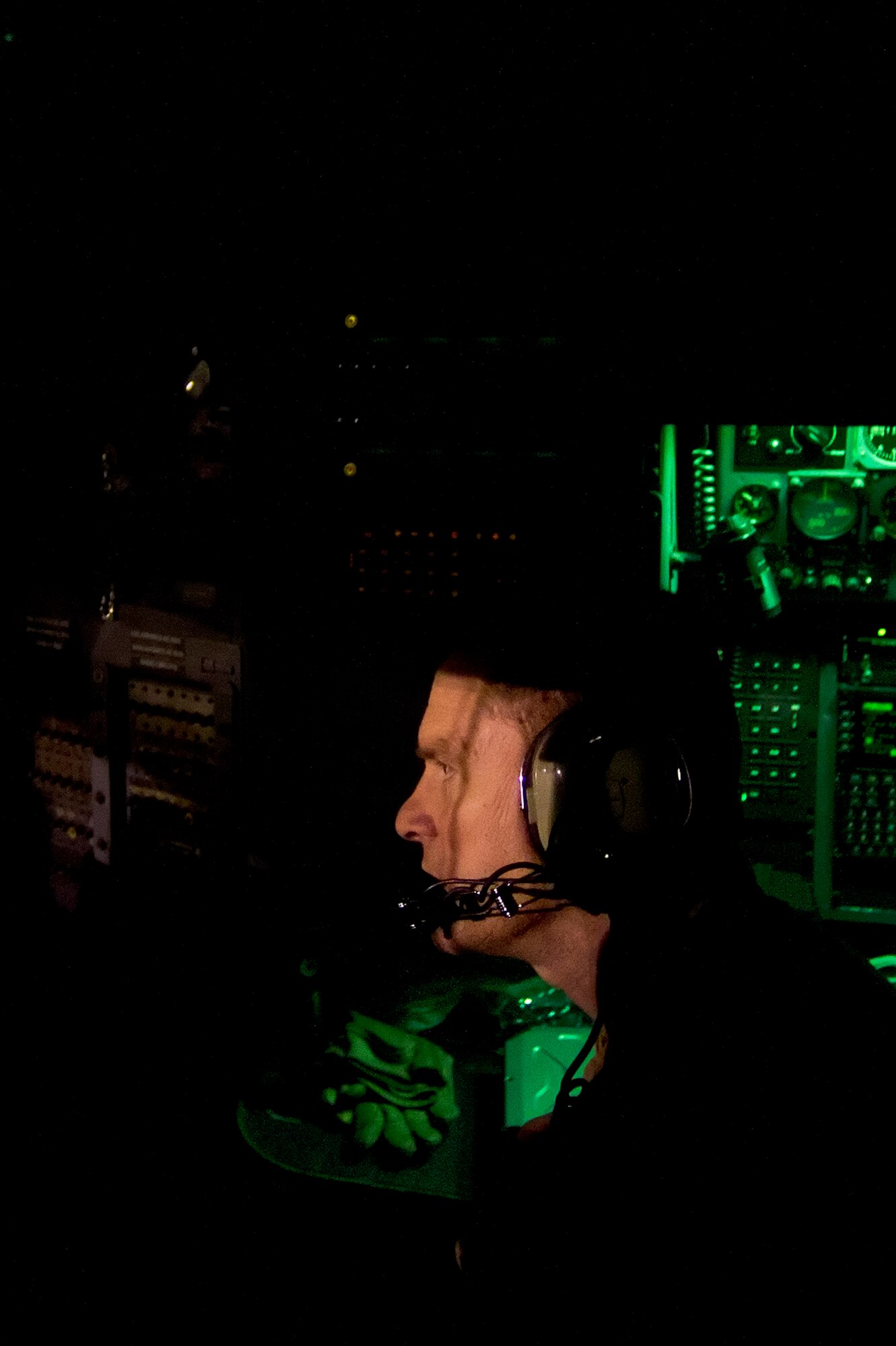 Lt. Col. John Bletner, 746th Expeditionary Airlift Squadron C-130 Hercules navigator, listens to radio chatter during an air transport mission in support of Operation New Dawn. The C-130 crew transported soldiers from the 4th Infantry Division out of Iraq on the first leg of their return trip home after completing their deployment. Bletner is deployed from the 107th Airlift Wing, Niagara Falls, N.Y.